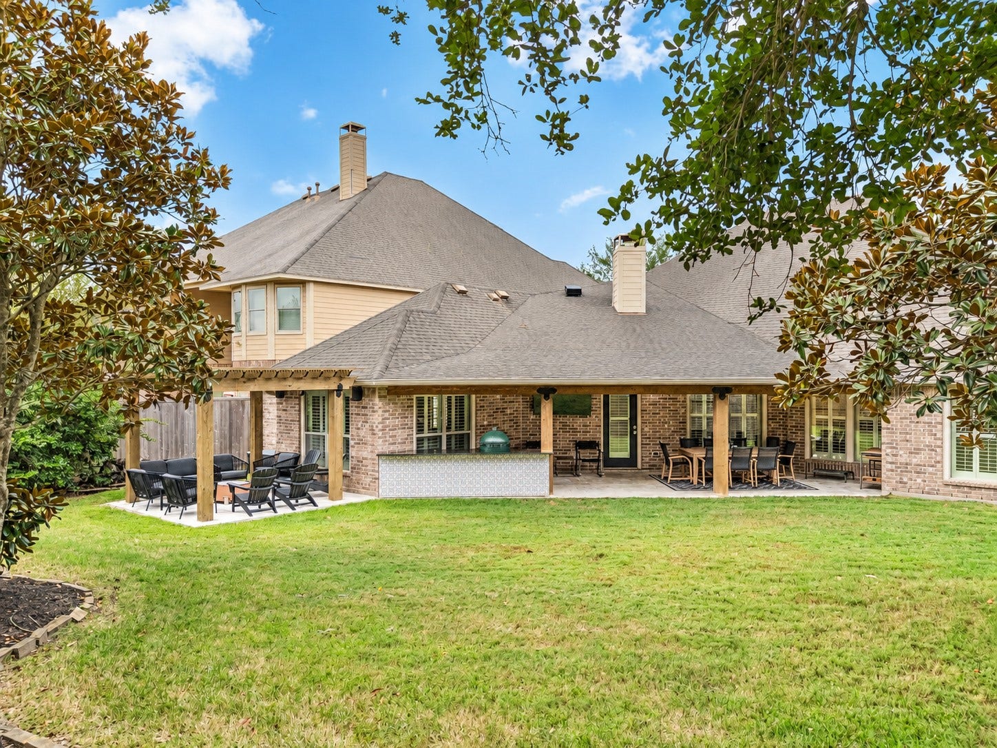 2927 Auburn Creek Lane, League City, TX 77573 Rear exterior view showcasing the home, covered patio, and open backyard.