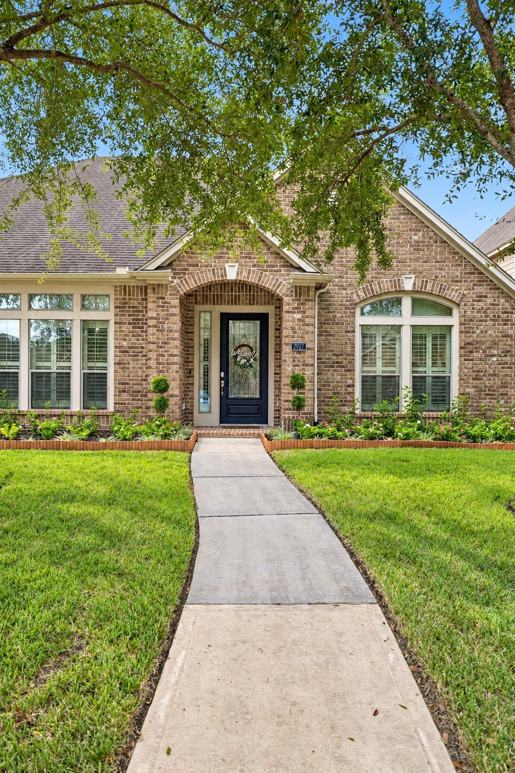 2927 Auburn Creek Lane, League City, TX 77573 Front exterior view highlighting the landscaped walkway, mature trees, and inviting curb appeal.