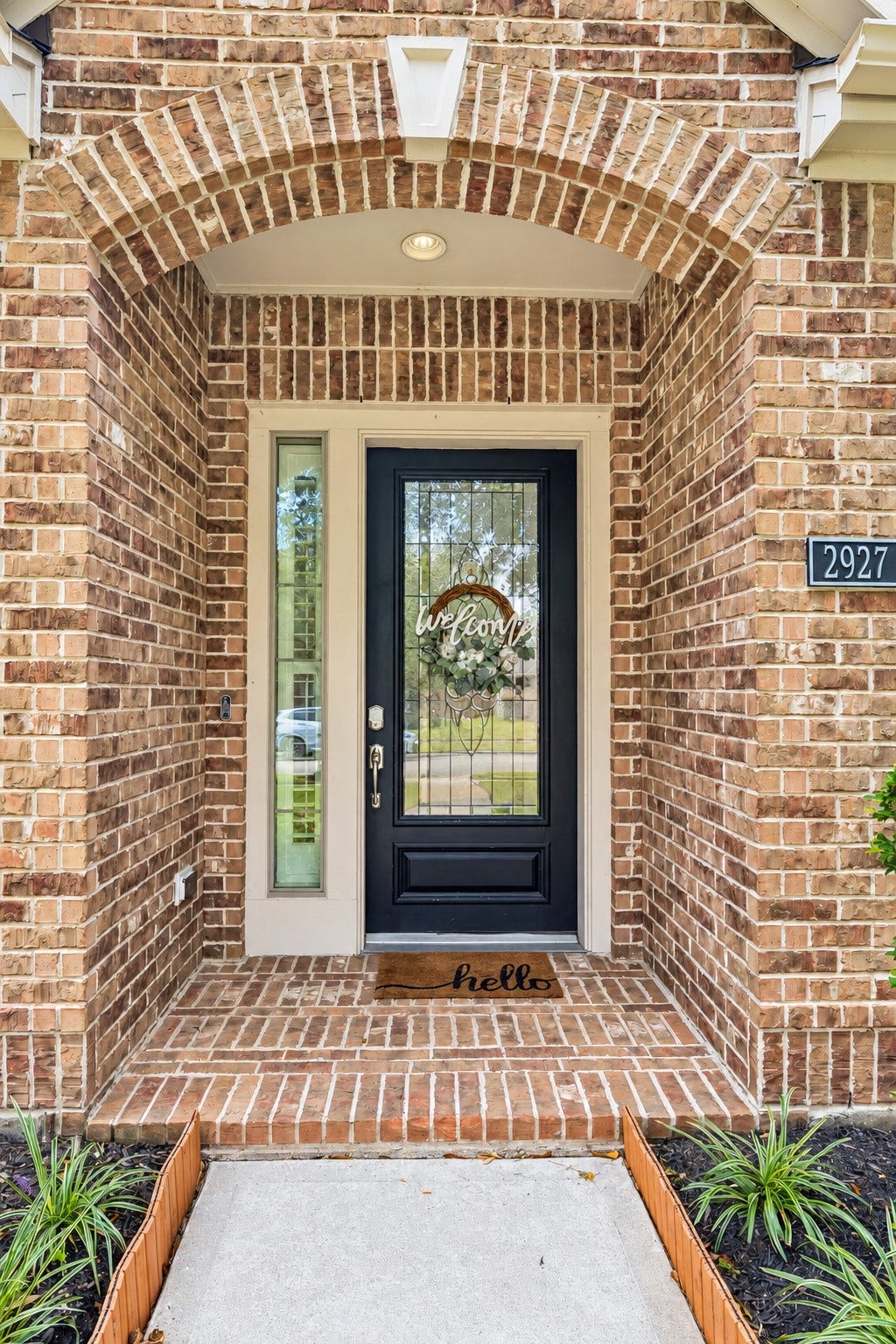 2927 Auburn Creek Lane, League City, TX 77573 Close-up of the front entry featuring brick detailing and a distinctive glass-paneled front door.