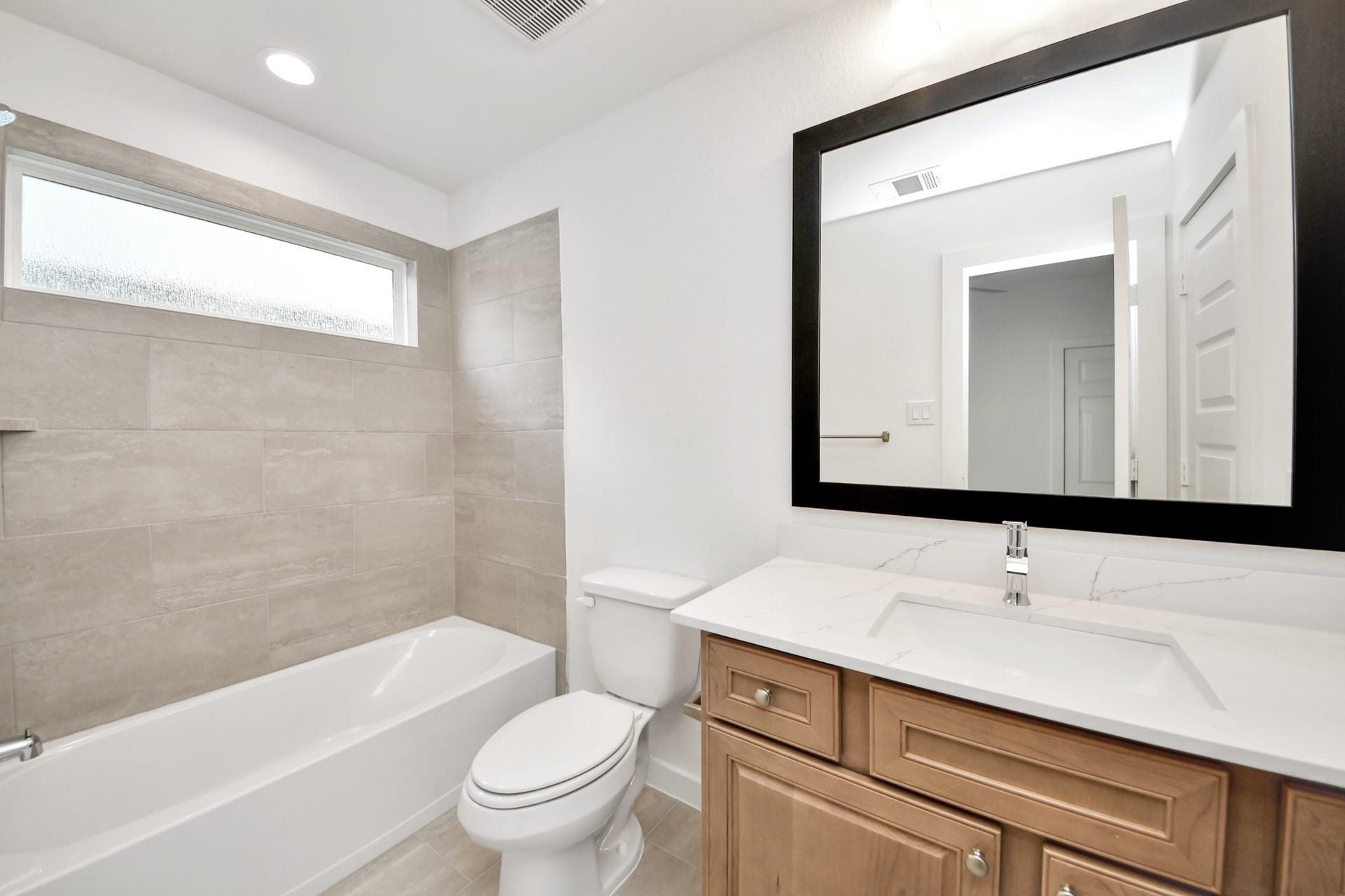 3217 Skerne Spring Drive, Spring, TX 77373 Secondary bath features tile flooring, bath/shower combo with tile surround, light stained wood cabinets, beautiful light countertop. Sample photo of completed home with similar floor plan. Actual colors and selections may vary.