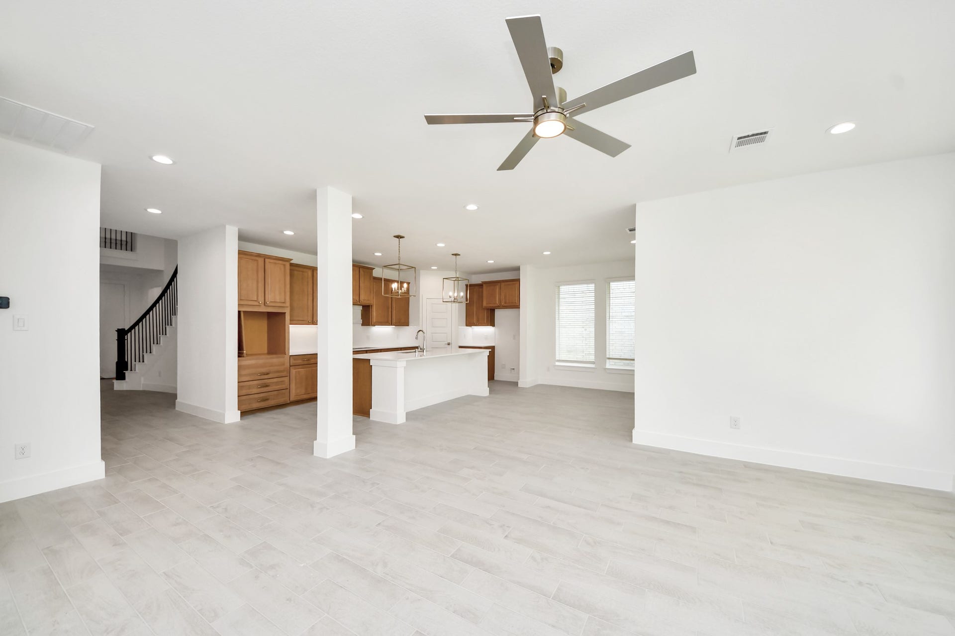 3217 Skerne Spring Drive, Spring, TX 77373 Family room flooded with natural light through the expansive windows. The premium tile flooring adds a touch of luxury to the space, creating the perfect setting for relaxing moments and cherished gatherings with loved ones. Sample photo of completed home with similar floor plan. Actual colors and selections may vary.