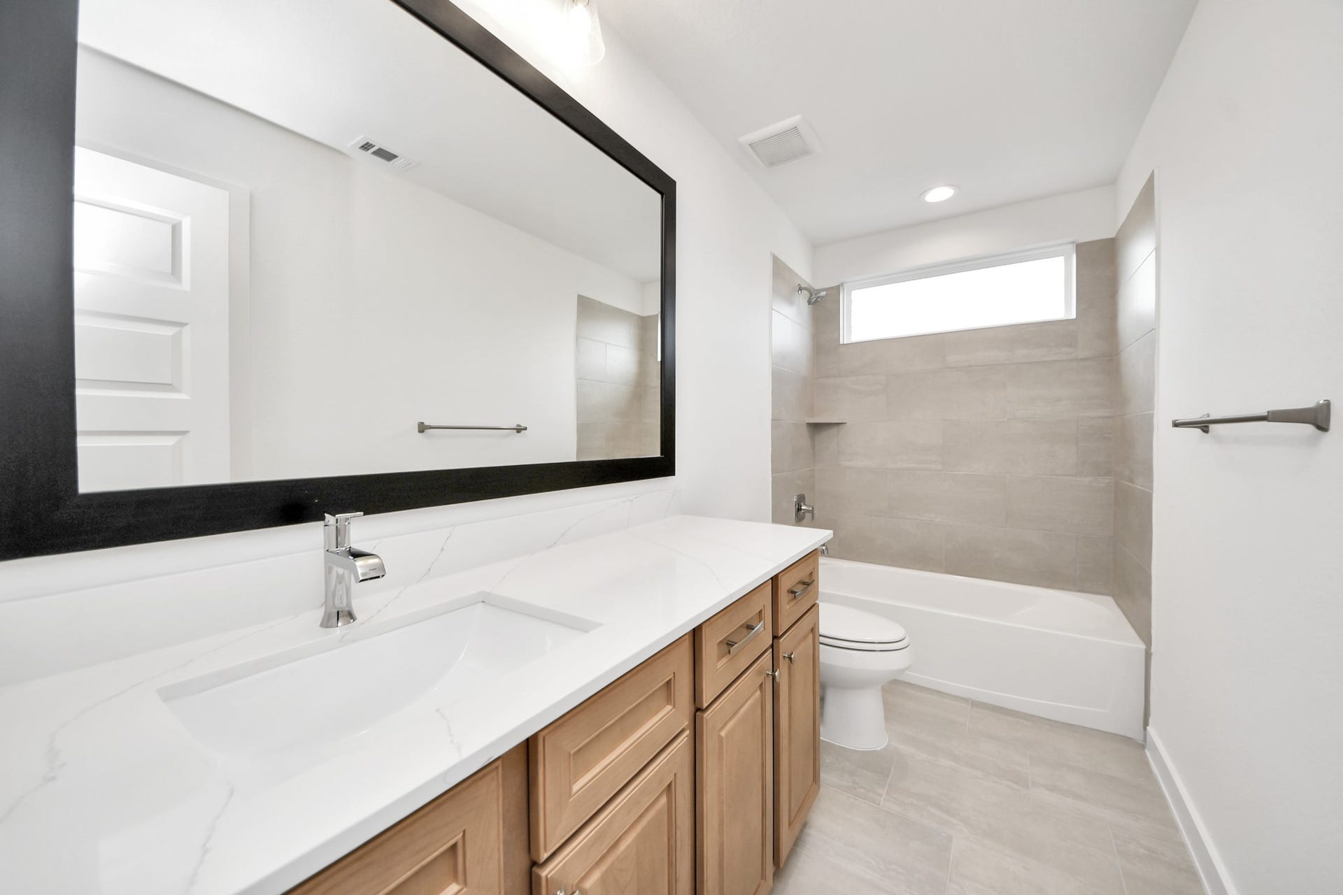 3217 Skerne Spring Drive, Spring, TX 77373 Secondary bath features tile flooring, bath/shower combo with tile surround, light stained wood cabinets, beautiful light countertop. Sample photo of completed home with similar floor plan. Actual colors and selections may vary.