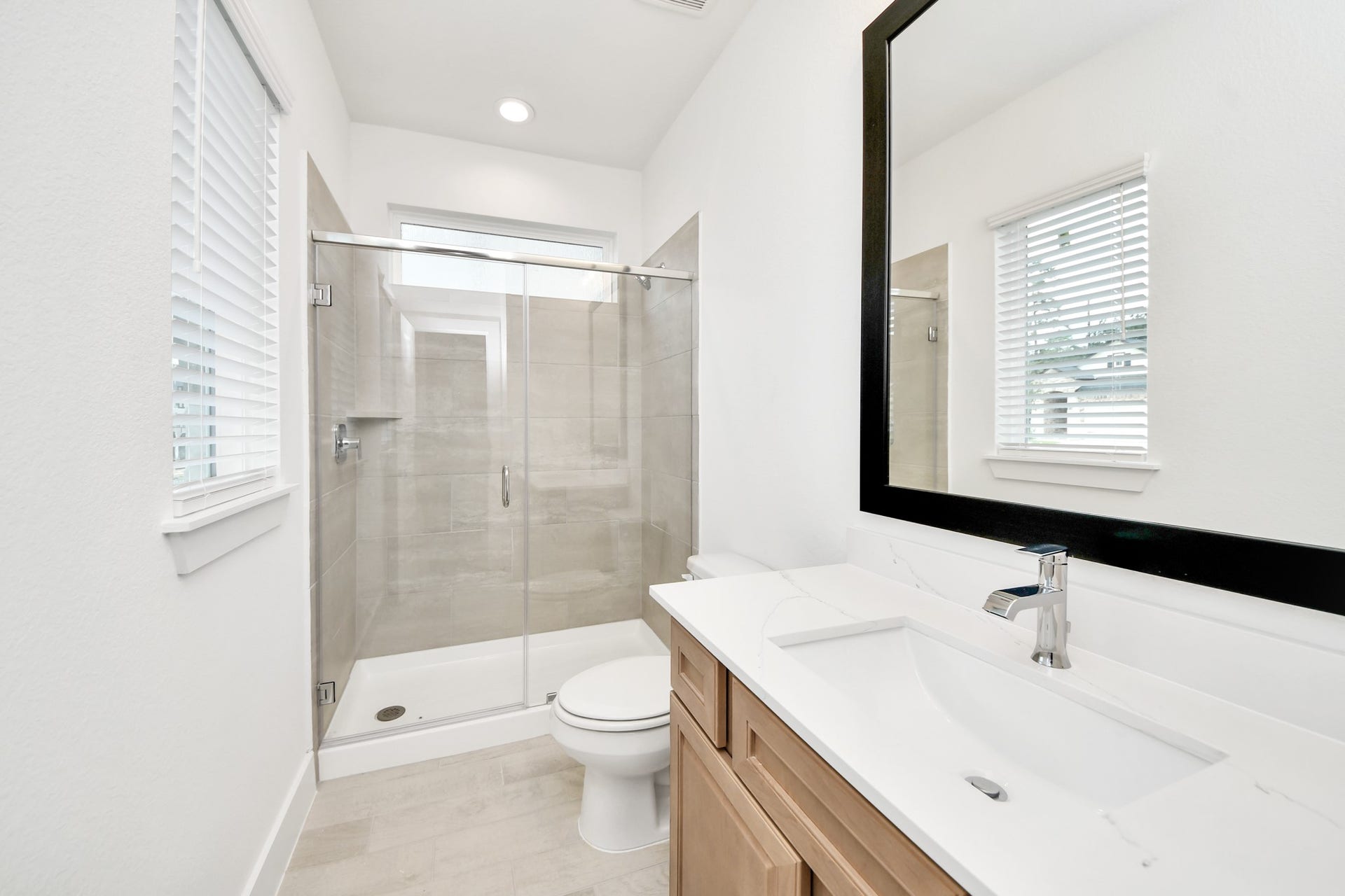 3217 Skerne Spring Drive, Spring, TX 77373 Secondary bath features tile flooring, walk-in shower with tile surround, light stained wood cabinets, beautiful light countertop. Sample photo of completed home with similar floor plan. Actual colors and selections may vary.