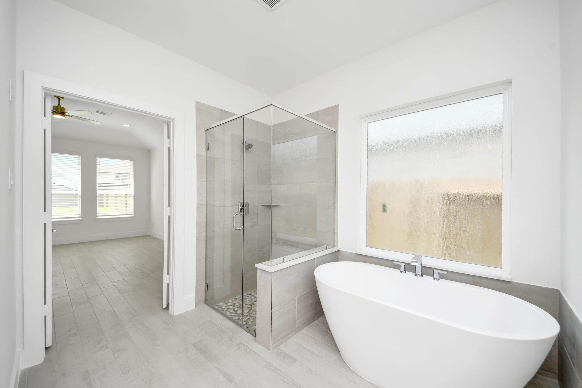 3217 Skerne Spring Drive, Spring, TX 77373 Indulge in a spa-like retreat within the confines of this primary bathroom. Delight in a spacious walk-in shower enveloped in stylish tile surround, unwind in a separate garden tub adorned with custom detailing. Sample photo of completed home with similar floor plan. Actual colors and selections may vary.