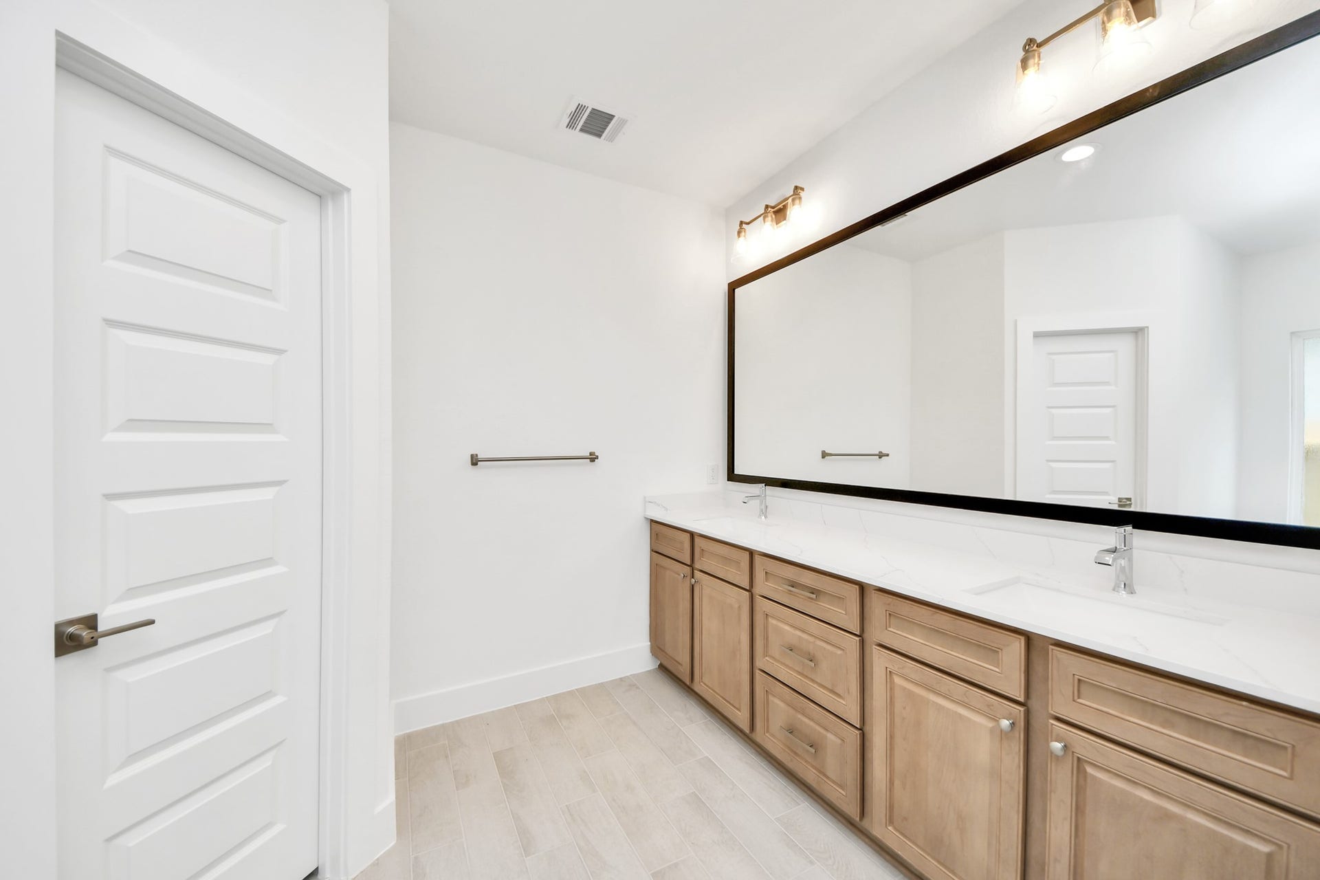 3217 Skerne Spring Drive, Spring, TX 77373 Elevate your daily routine at the elegant vanity, now equipped with double sinks, light countertops, modern hardware, and beautiful vanity lights. Sample photo of completed home with similar floor plan. Actual colors and selections may vary.