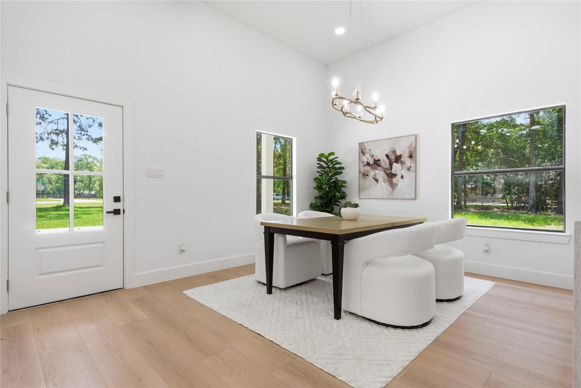 40203 Cimarron Way, Magnolia, TX 77354 Bright dining area with statement chandelier, designer lighting, and gorgeous natural light from the front entry. Wide-plank luxury vinyl floors and clean modern lines create an elevated everyday dining experience.