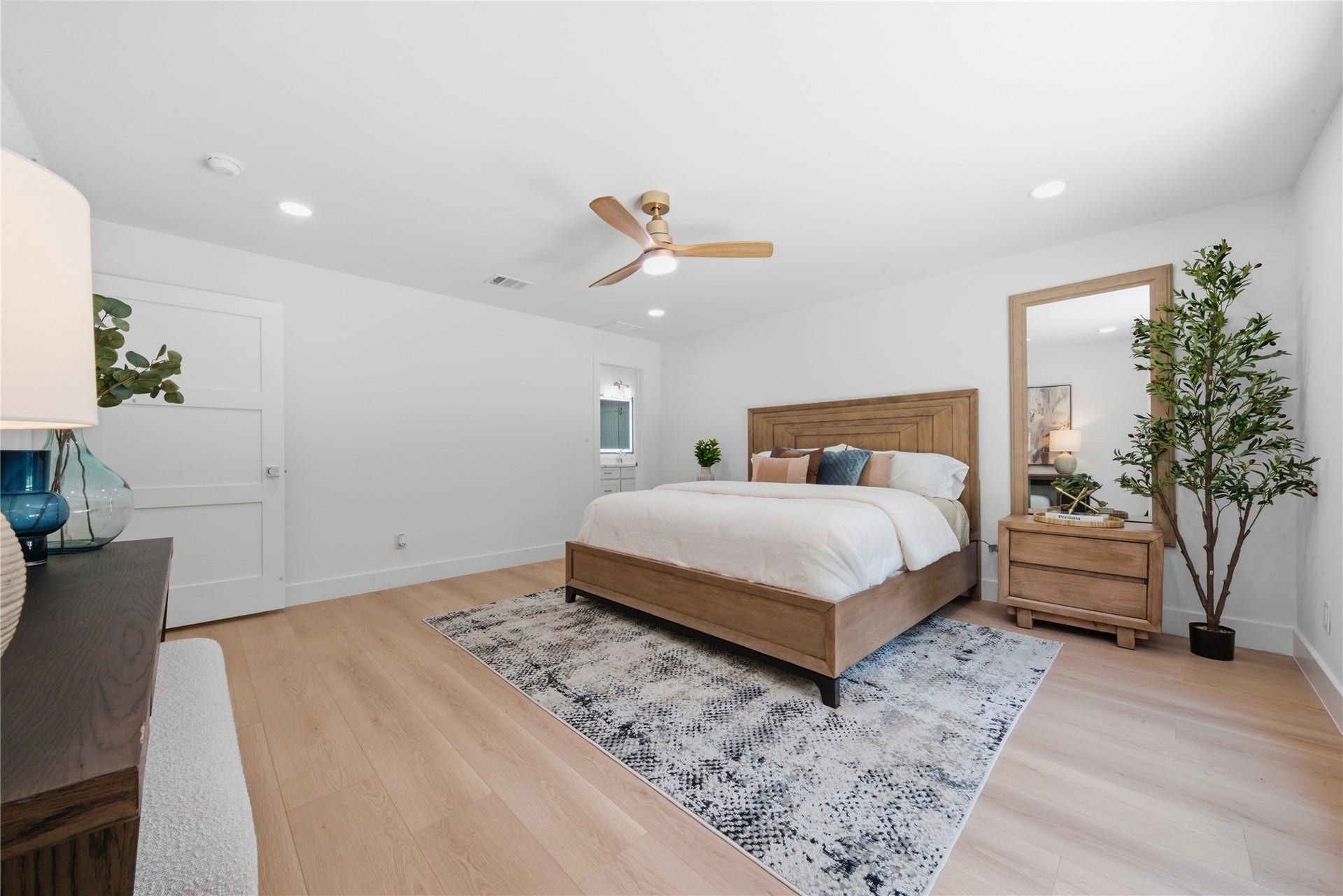 40203 Cimarron Way, Magnolia, TX 77354 First-floor primary suite showing access to the ensuite spa bath and oversized footprint. Standard ceiling, designer fan, and natural light pour into this main-level retreat.