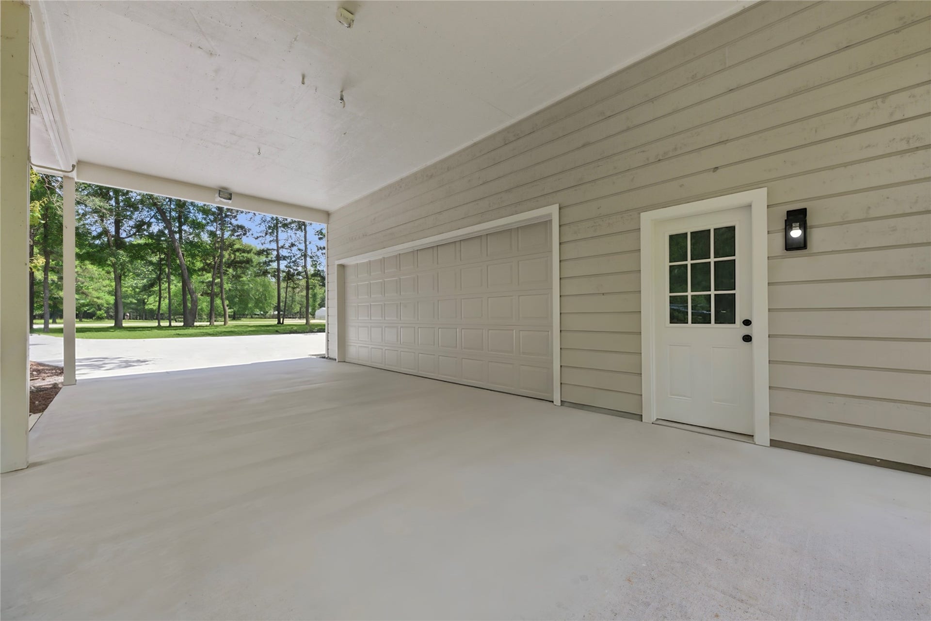 40203 Cimarron Way, Magnolia, TX 77354 Covered drive-through area connecting the main home to the detached garage structure. Side-entry door access leads to the detached building's flex space. Sheltered access in all weather.