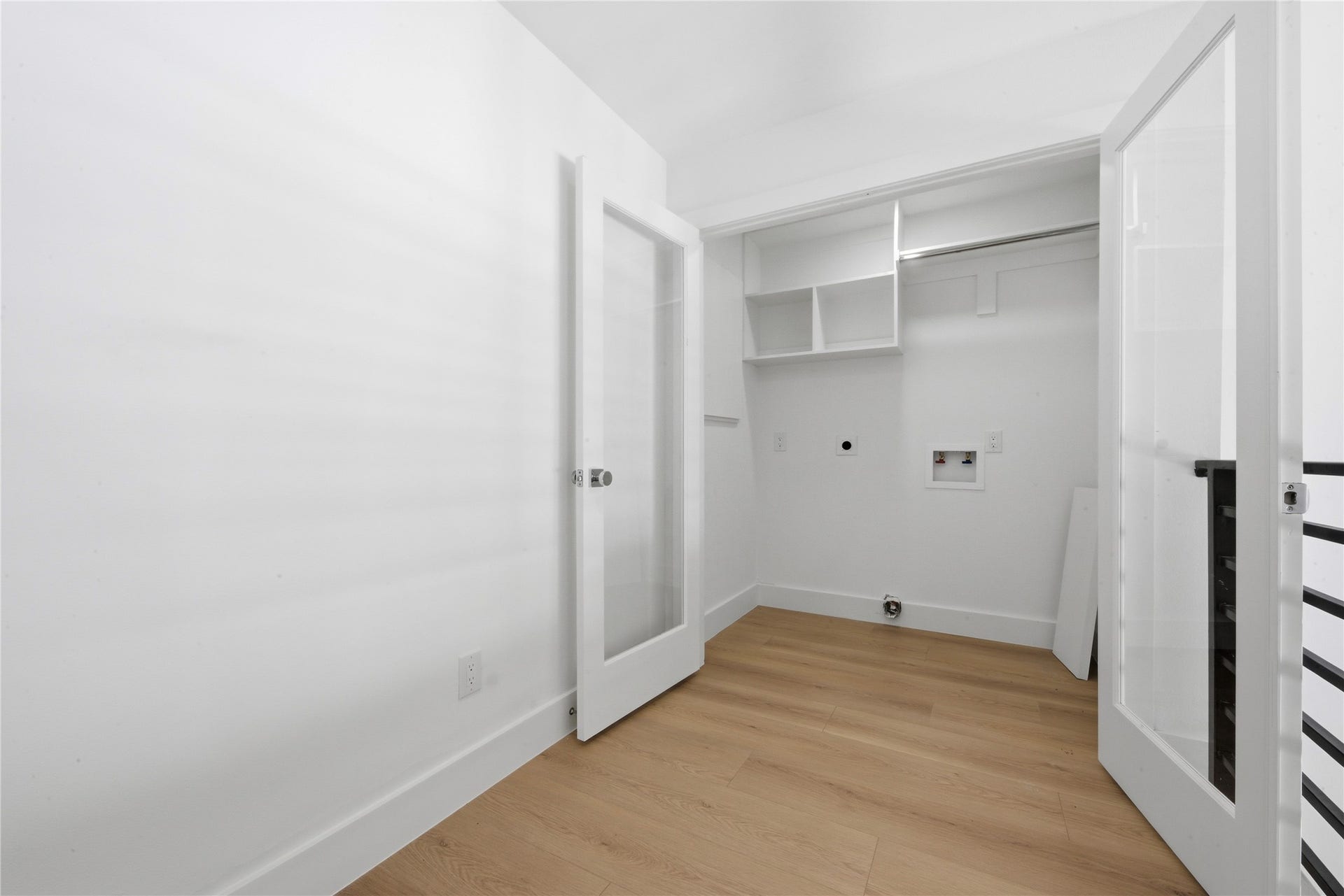 40203 Cimarron Way, Magnolia, TX 77354 Bright second-floor utility room with washer/dryer hookups, built-in shelving, recycled-glass French doors, and wide-plank floors. Convenient placement near the secondary bedrooms.