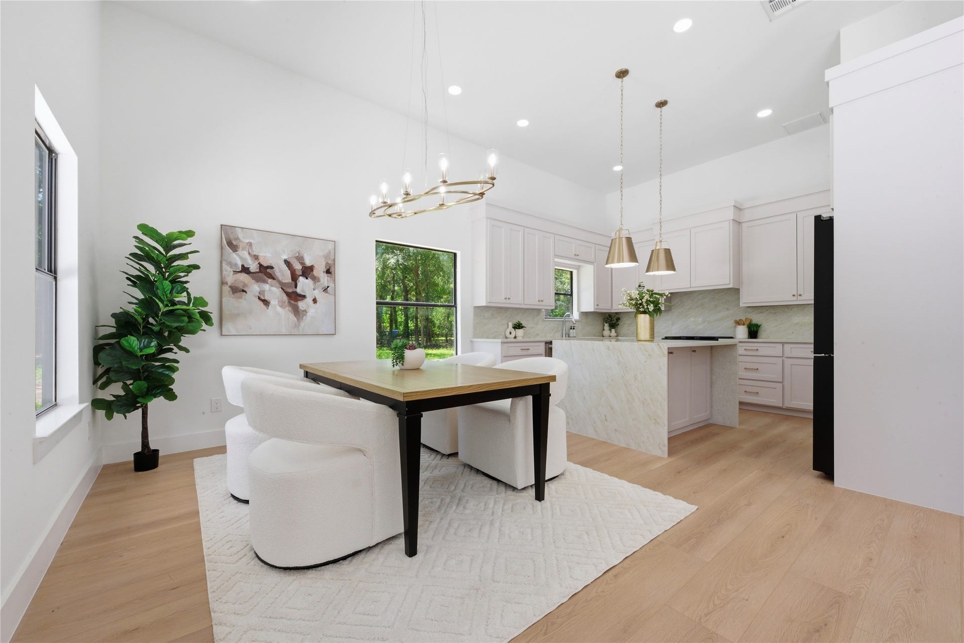 40203 Cimarron Way, Magnolia, TX 77354 Designer chef's kitchen featuring waterfall quartz island, custom soft-close cabinetry, quartz countertops, brass pendant lighting, statement chandelier, gas range, and walk-in pantry. Refrigerator included.