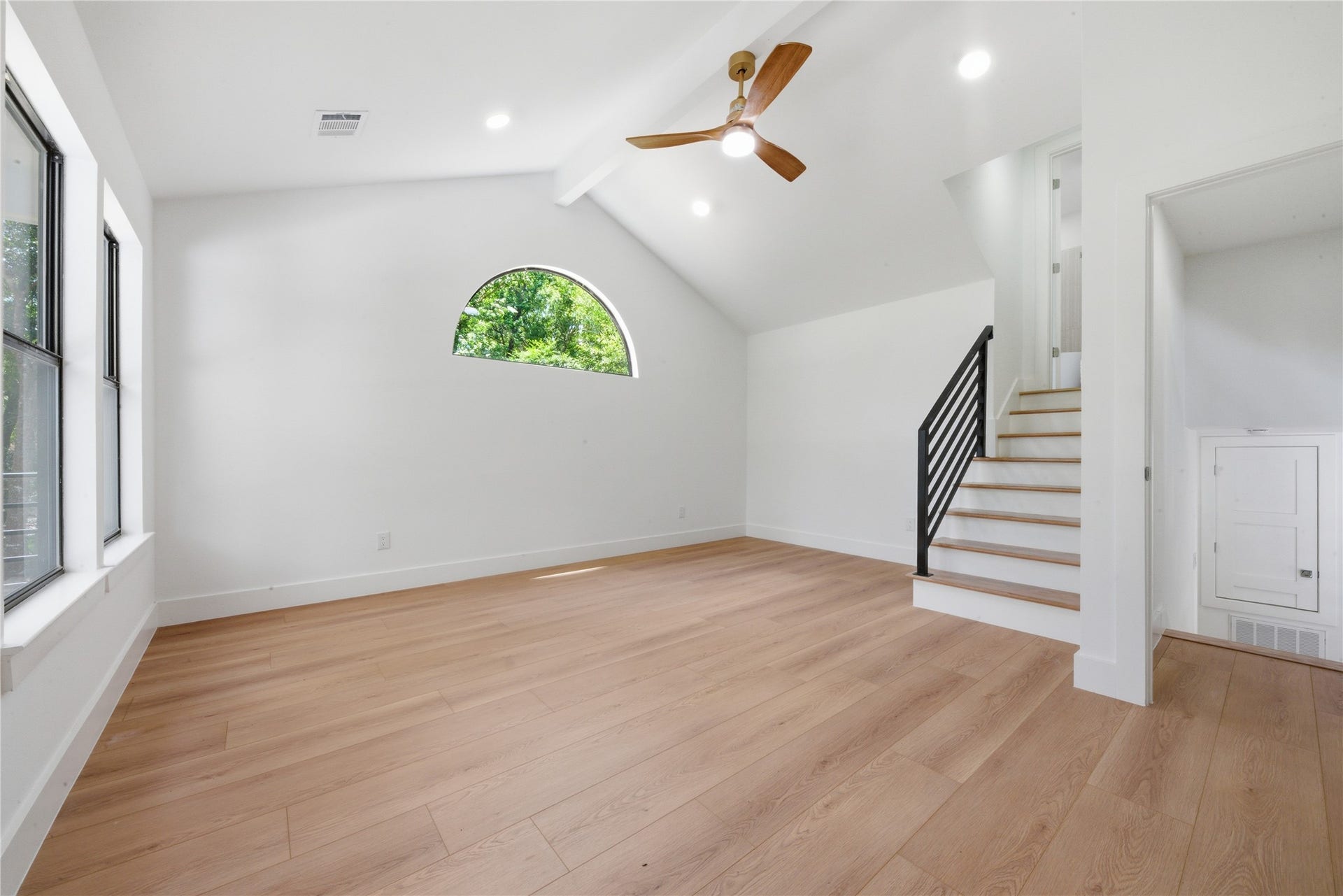 40203 Cimarron Way, Magnolia, TX 77354 Stunning vaulted second primary suite featuring exposed white beam, half-moon accent window, and private interior staircase to the 4th-floor ensuite with soaking tub and walk-in closet.
