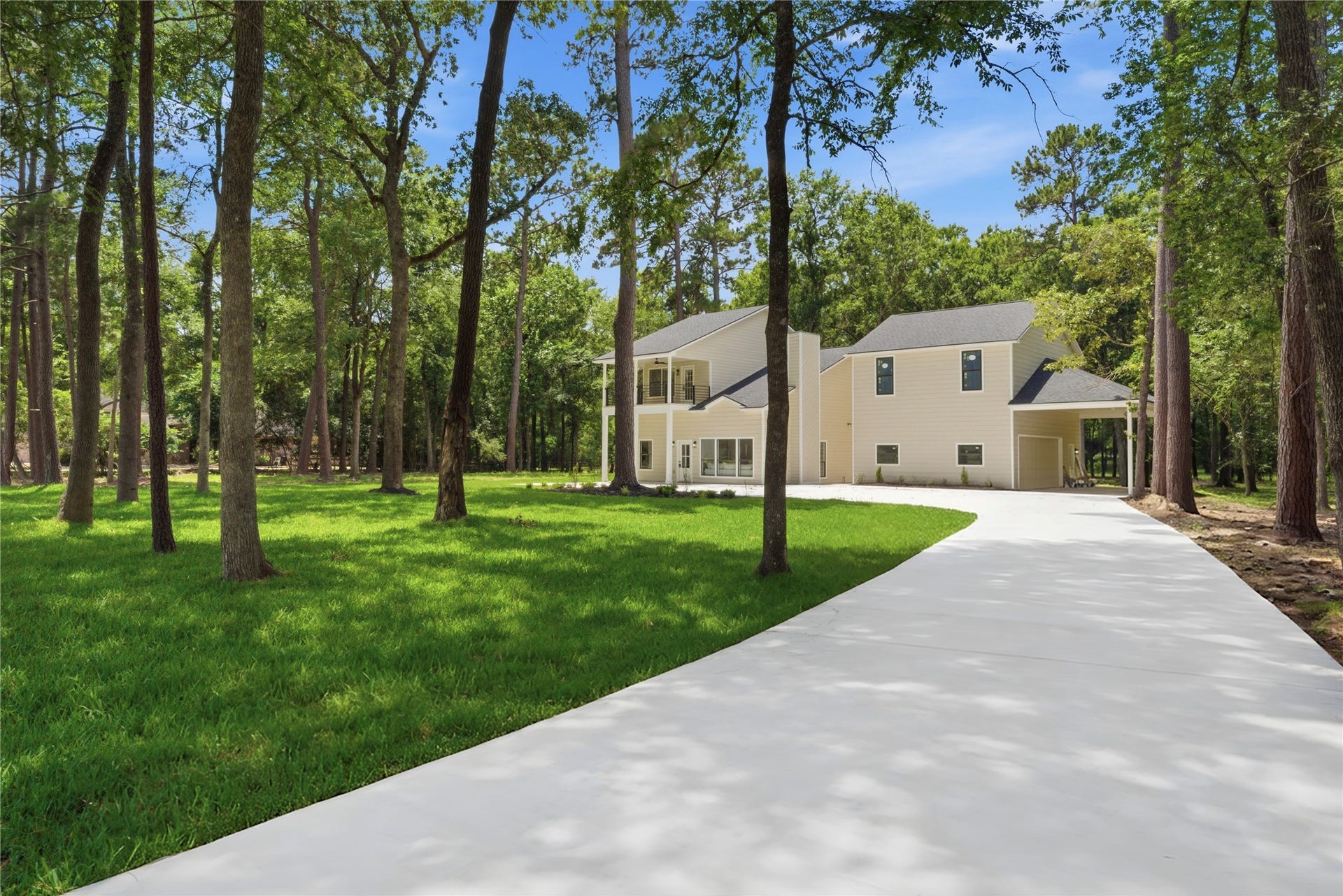 40203 Cimarron Way, Magnolia, TX 77354 Long approach view of the property showing your home, covered drive-through, and detached structure positioned among mature pines. The 1.67-acre lot offers exceptional privacy from neighboring homes.