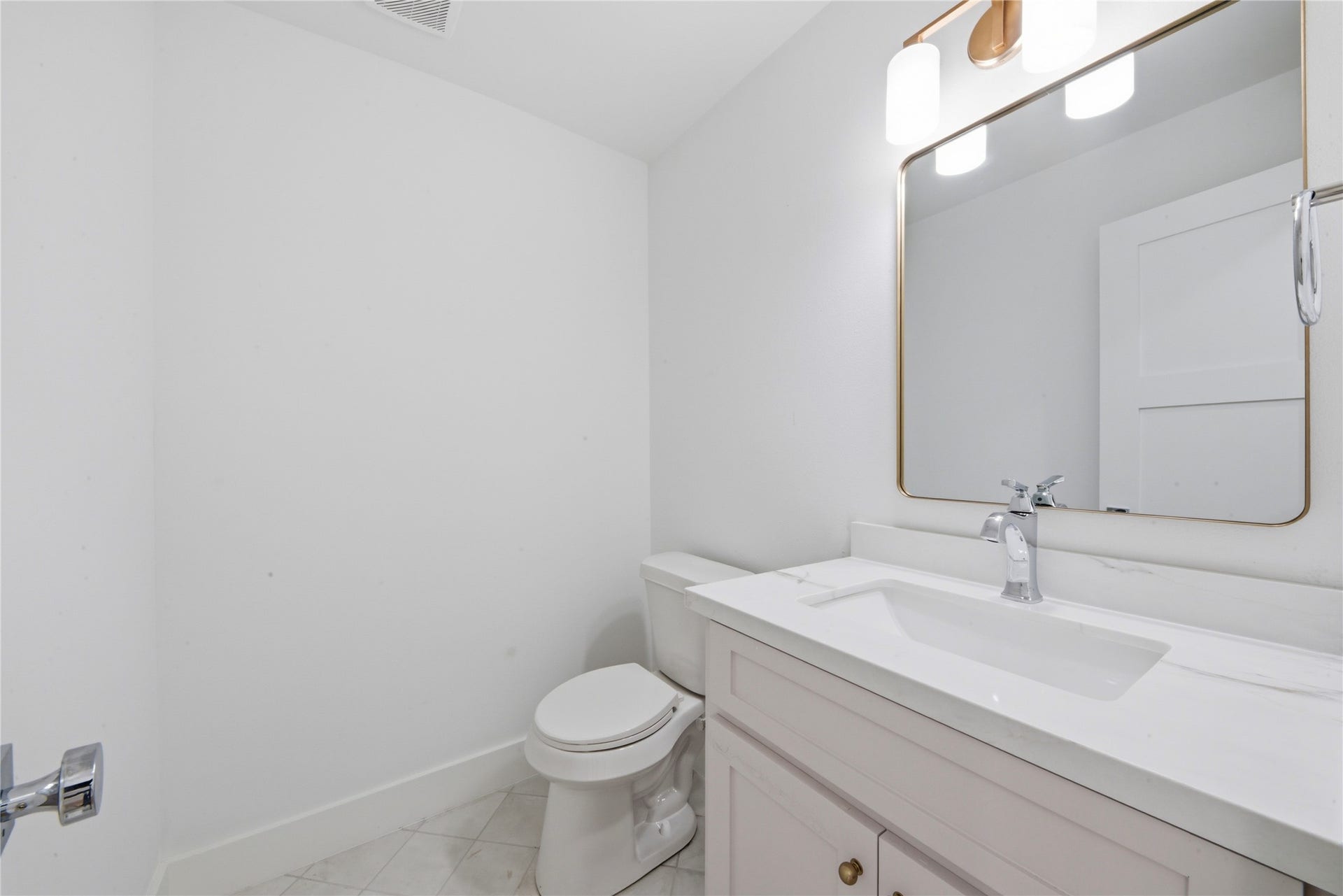 40203 Cimarron Way, Magnolia, TX 77354 Elegant powder bath featuring custom vanity with quartz counter, brass-framed mirror, designer brass sconce lighting, and tile flooring. Conveniently located on the main floor.