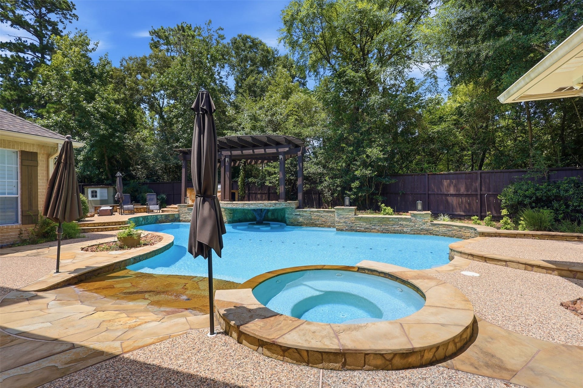 74 W Thymewood Place, The Woodlands, TX 77382 Resurfaced pool in 2026 over looking resort style pool with cascading water fall grotto