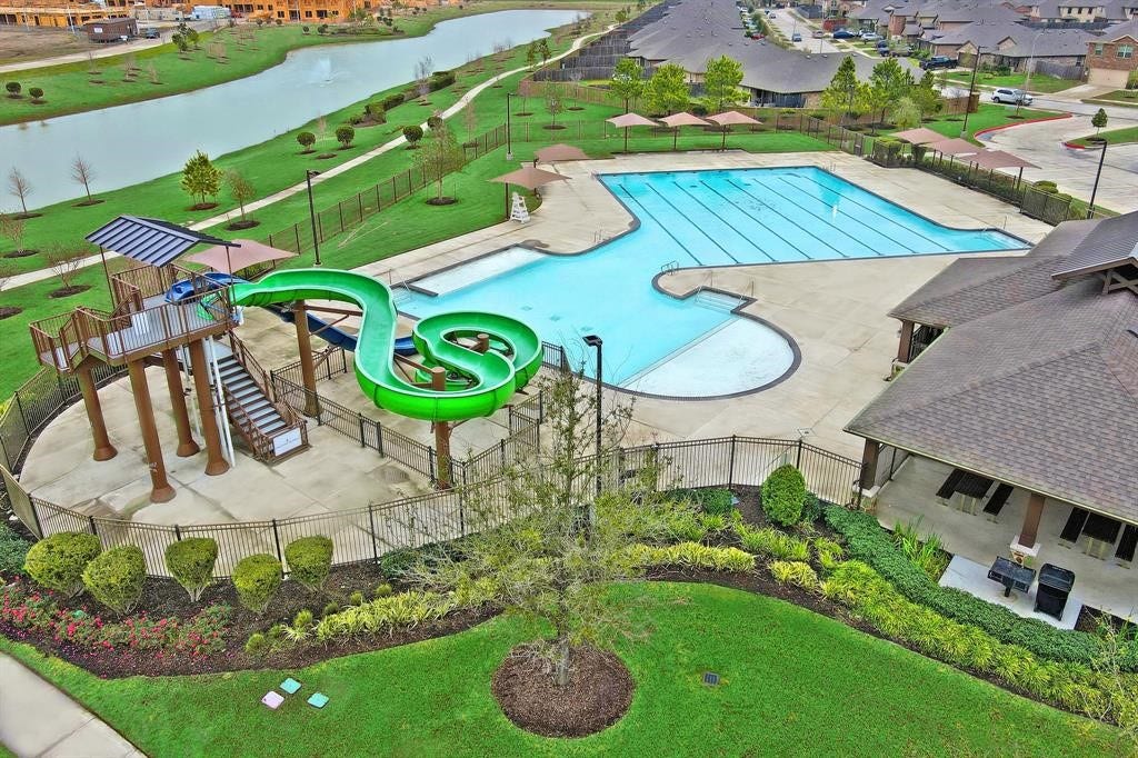 Huge Swimming Pool! One side with beach front walk in entrance and huge Water Slide! The other side is a Lap Pool! Call today! Fantastic Community with lots to offer!