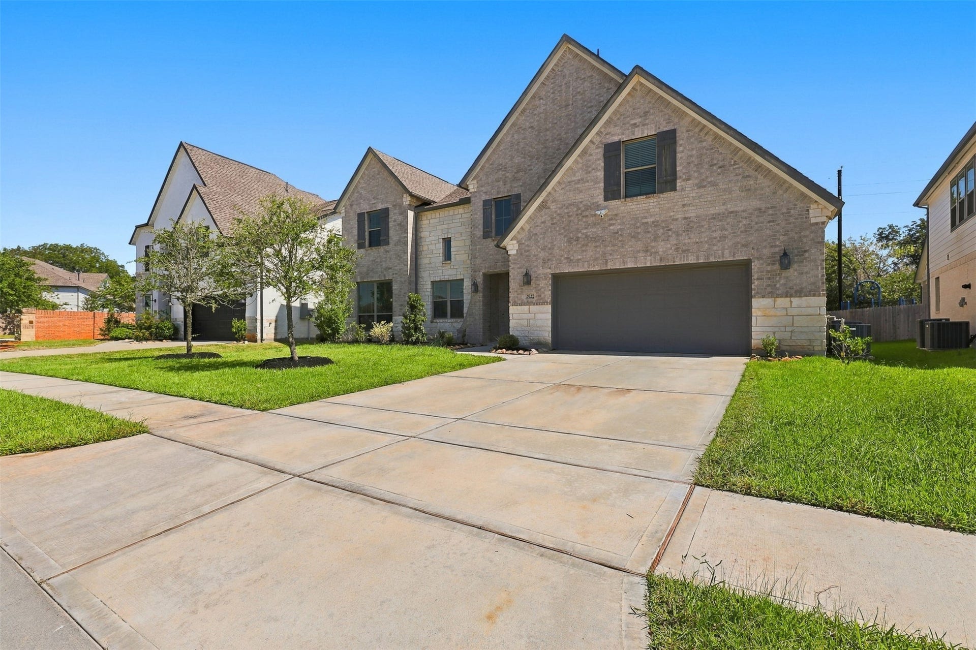 2922 Opal Ivory Way, Richmond, TX 77406 Charming two-story home with a modern brick exterior, featuring a spacious driveway and well-maintained front lawn.