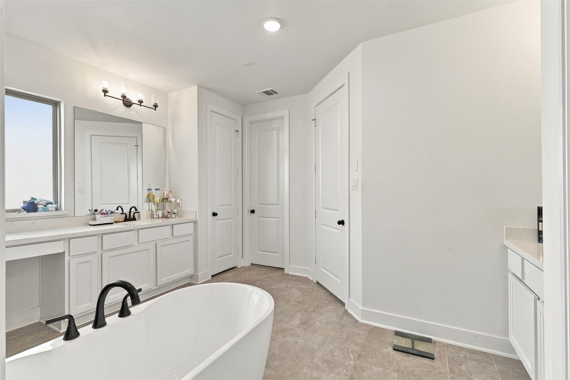 2922 Opal Ivory Way, Richmond, TX 77406 Spacious bathroom featuring a luxurious freestanding tub, dual vanities with modern fixtures, and ample storage in a clean, elegant design.