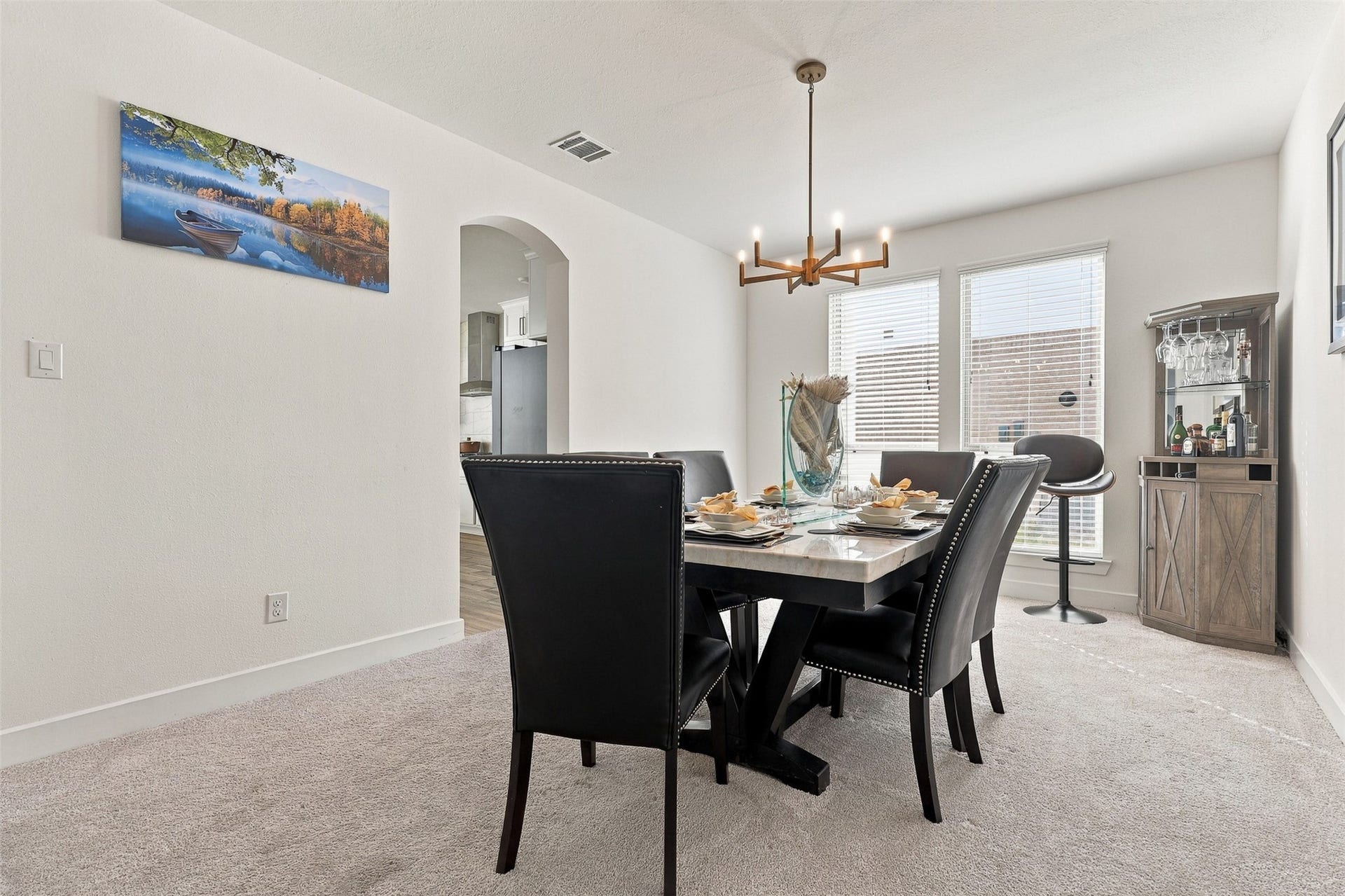 2922 Opal Ivory Way, Richmond, TX 77406 Elegant dining area with a modern chandelier, cozy seating for six, and abundant natural light from large windows.