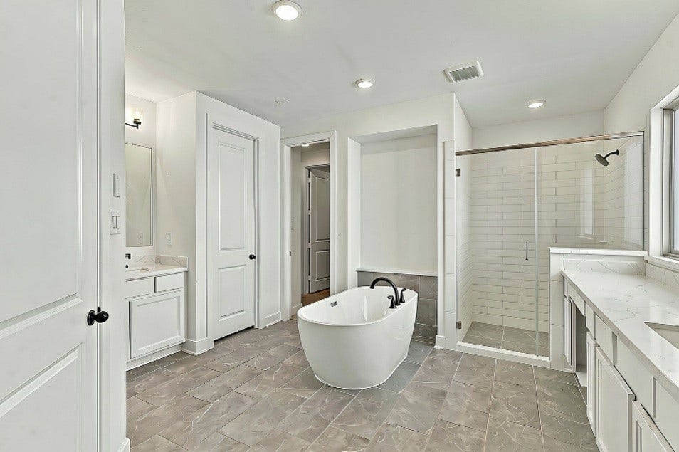 2922 Opal Ivory Way, Richmond, TX 77406 Luxurious bathroom featuring a modern freestanding tub, spacious glass-enclosed shower, dual vanities, and elegant tile flooring.