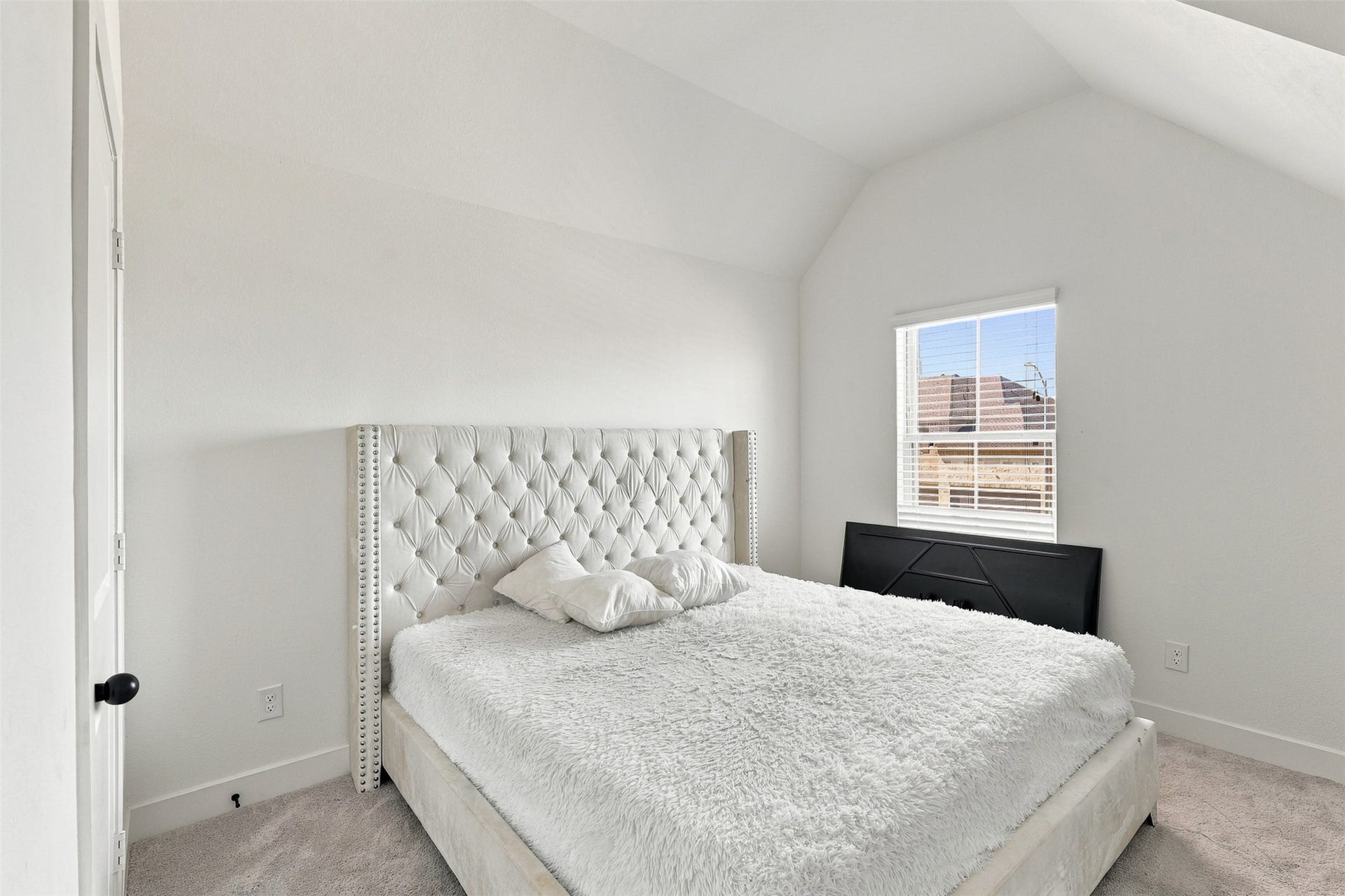 2922 Opal Ivory Way, Richmond, TX 77406 Cozy bedroom with a plush, tufted headboard and soft carpeting, filled with natural light from a large window.
