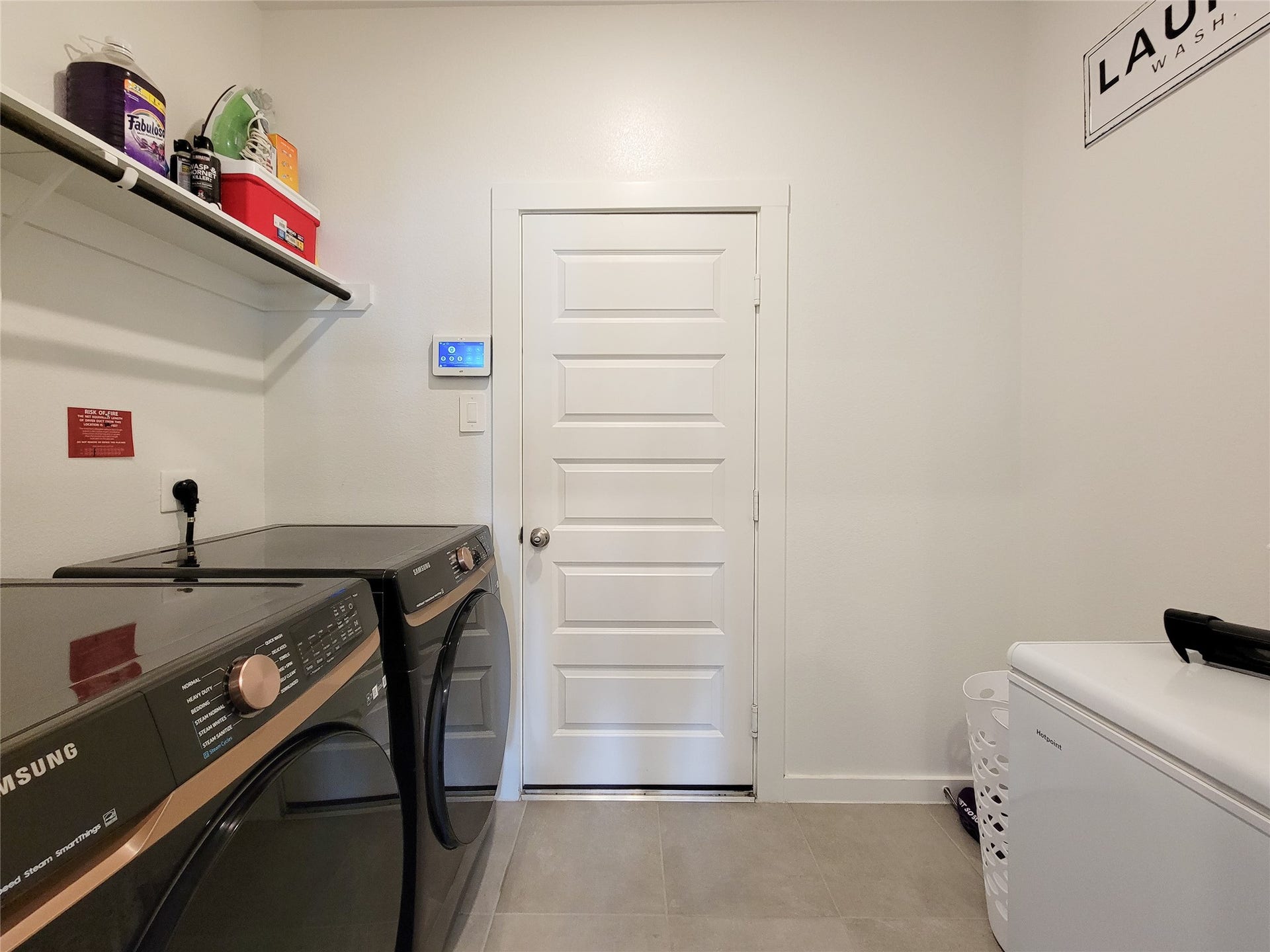10843 Bodie Hills Drive, Rosharon, TX 77583 Modern laundry room featuring sleek appliances, ample shelving, and a convenient layout for efficient organization.