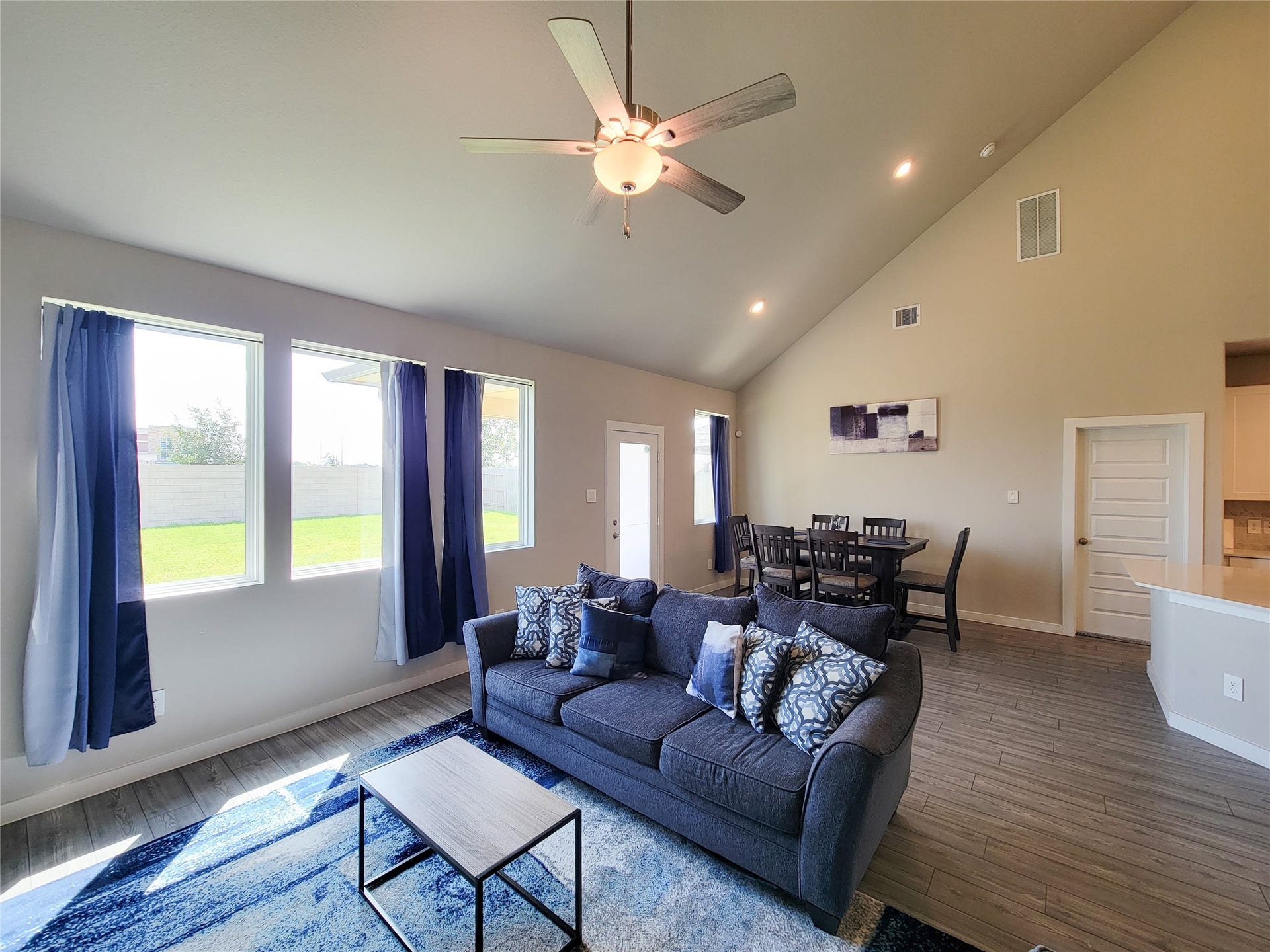 10843 Bodie Hills Drive, Rosharon, TX 77583 Spacious living area with high ceilings and abundant natural light, featuring a comfortable seating arrangement and adjacent dining space, perfect for entertaining.
