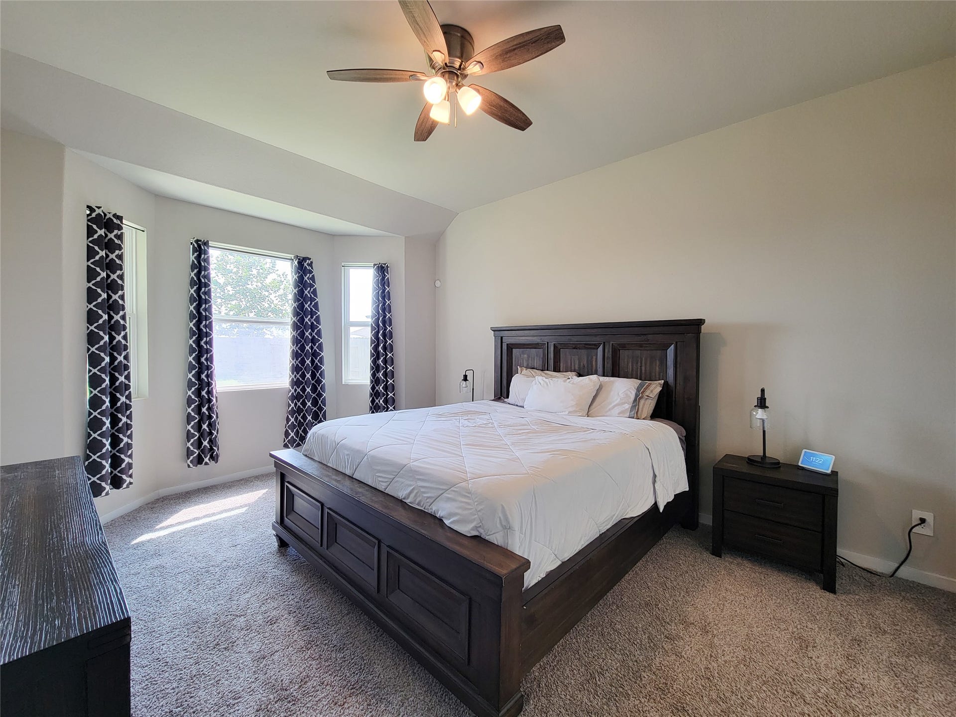 10843 Bodie Hills Drive, Rosharon, TX 77583 Spacious bedroom with plush carpeting, a large window for natural light, and a ceiling fan for comfort.