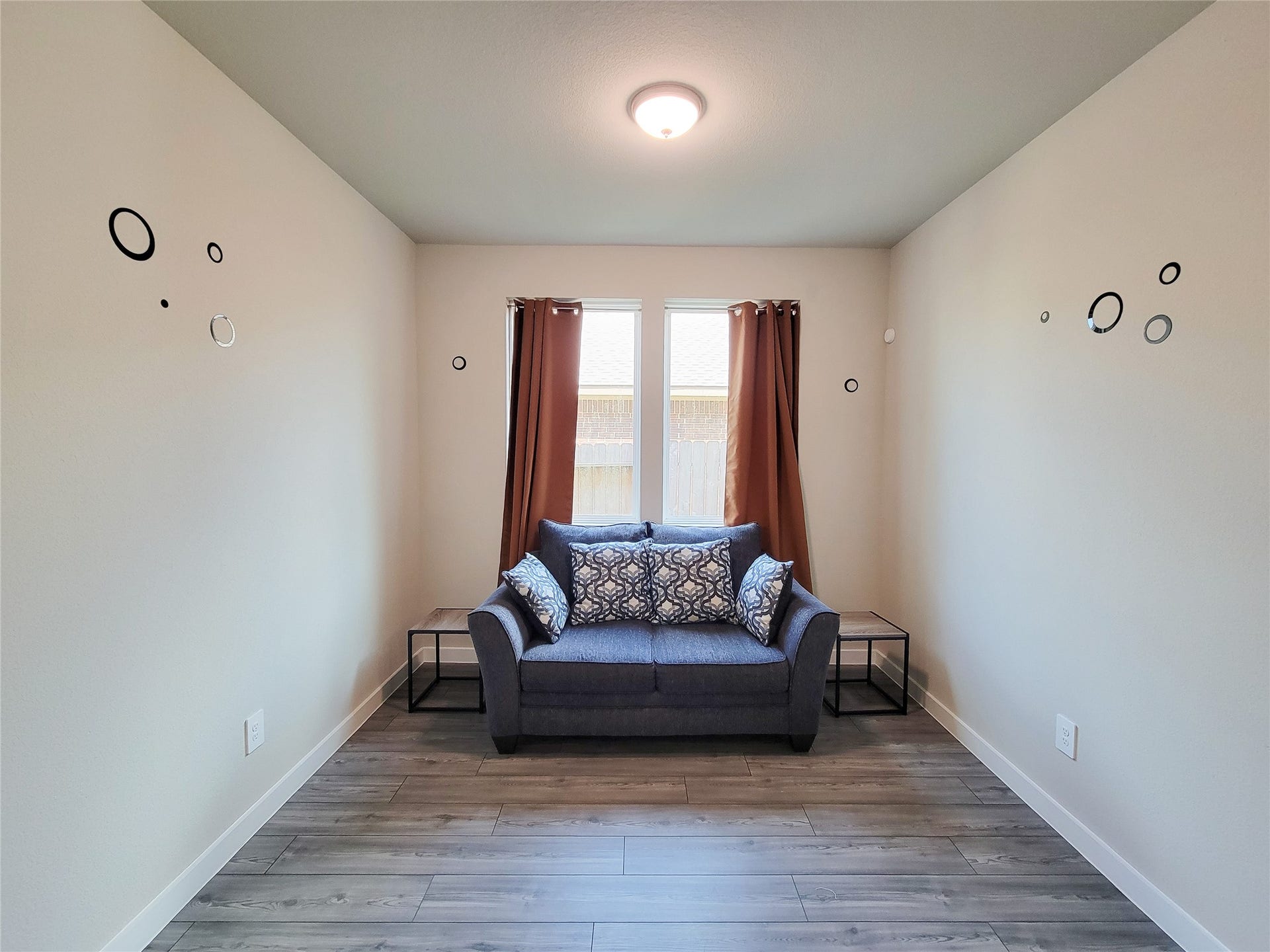 10843 Bodie Hills Drive, Rosharon, TX 77583 Cozy sitting area with modern decor, featuring a comfortable loveseat, accent pillows, and ample natural light from the window.
