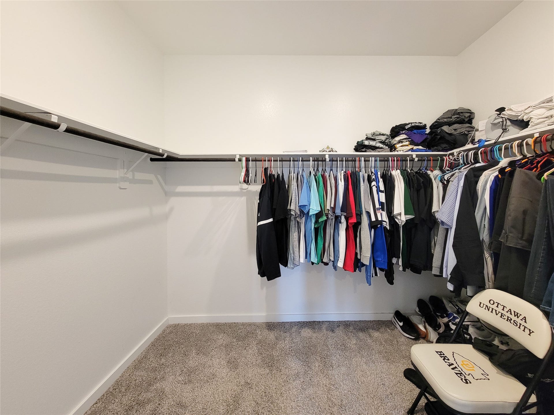 10843 Bodie Hills Drive, Rosharon, TX 77583 Spacious walk-in closet with ample hanging space, shelving, and soft carpet flooring, perfect for organizing your wardrobe.