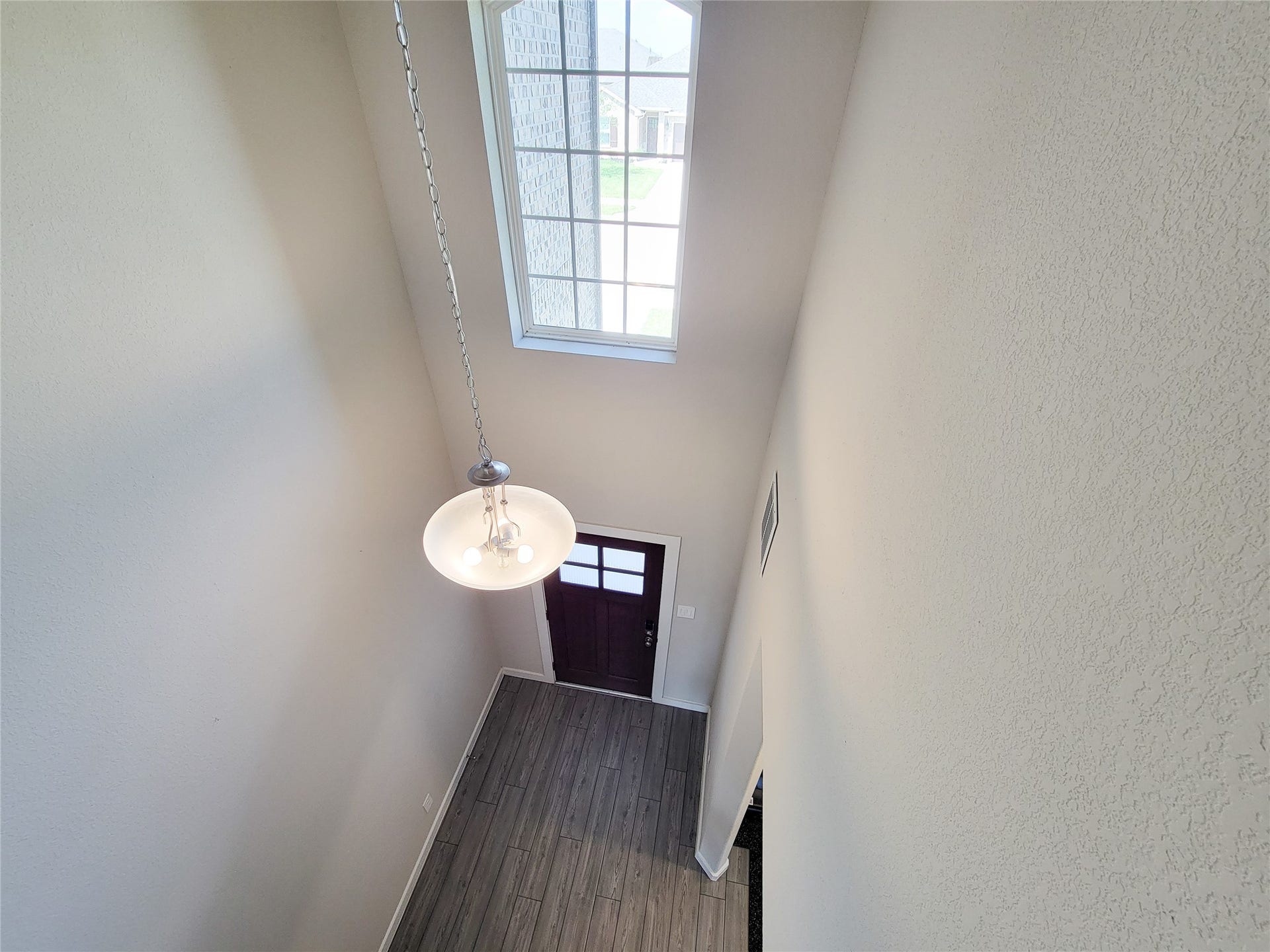 10843 Bodie Hills Drive, Rosharon, TX 77583 Bright and airy foyer with high ceilings, large window, and elegant hanging light fixture, welcoming you into the home.