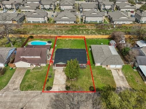 11007 Green Arbor Drive, Houston, TX 77089 This aerial photo shows a single-story home with a newer roof, highlighted by a red boundary line. The property features a spacious front yard with a two car driveway and a central tree.