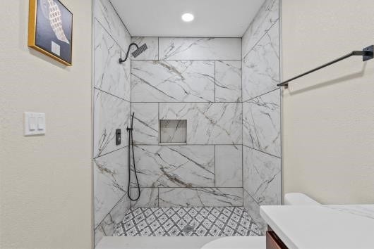 11007 Green Arbor Drive, Houston, TX 77089 Renovated full bathroom with new cabinets, and quartz countertops. Accessories include a rainfall shower head and upgraded faucets.
