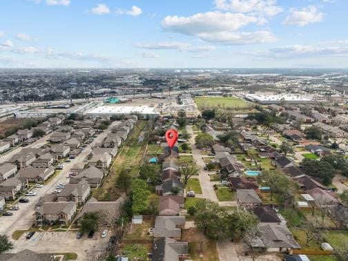 11007 Green Arbor Drive, Houston, TX 77089 This aerial photo showcases a suburban neighborhood with rows of houses, tree-lined streets, and nearby commercial areas. The area is marked by a prominent pin, indicating a specific property of interest. The surroundings include ample green spaces and easy access to amenities.