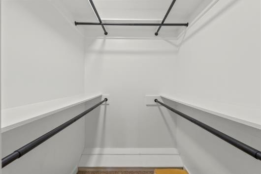 11007 Green Arbor Drive, Houston, TX 77089 Spacious walk-in closet with multiple hanging rods, offering ample storage space and a clean, modern design. Primary bedroom