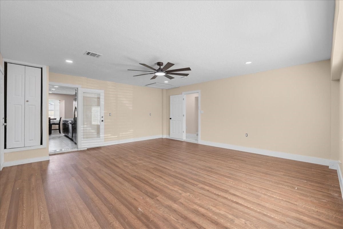 11007 Green Arbor Drive, Houston, TX 77089 Flex room with wood like floor, ceiling fan, looking back into kitchen area.