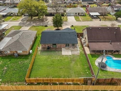 11007 Green Arbor Drive, Houston, TX 77089 This aerial photo shows a single-story brick house with a new roof, located in a suburban neighborhood. It features a spacious, fenced backyard with a large patio.