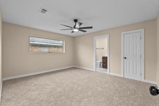 11007 Green Arbor Drive, Houston, TX 77089 This spacious primary bedroom features neutral-painted walls and carpet, a ceiling fan for comfort, and ample natural light from a large window. It includes an en-suite bathroom and a walk in closet for convenience.