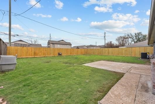 11007 Green Arbor Drive, Houston, TX 77089 This photo showcases a spacious backyard with a well-maintained lawn, surrounded by a wooden fence for privacy. A concrete patio area offers space for outdoor activities or entertaining.
