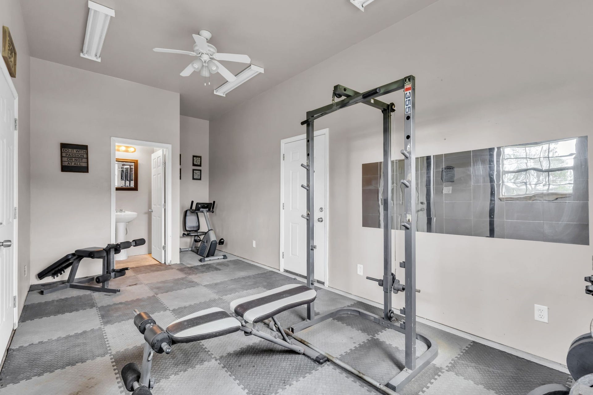 11010 Madison Court, Beaumont, TX 77705 Additional flexible space located inside the detached garage, currently used as a private home gym. Features a convenient half bath, ceiling fan, and dedicated space for a potential shower addition. Ideal for a fitness room, hobby space, or home office.