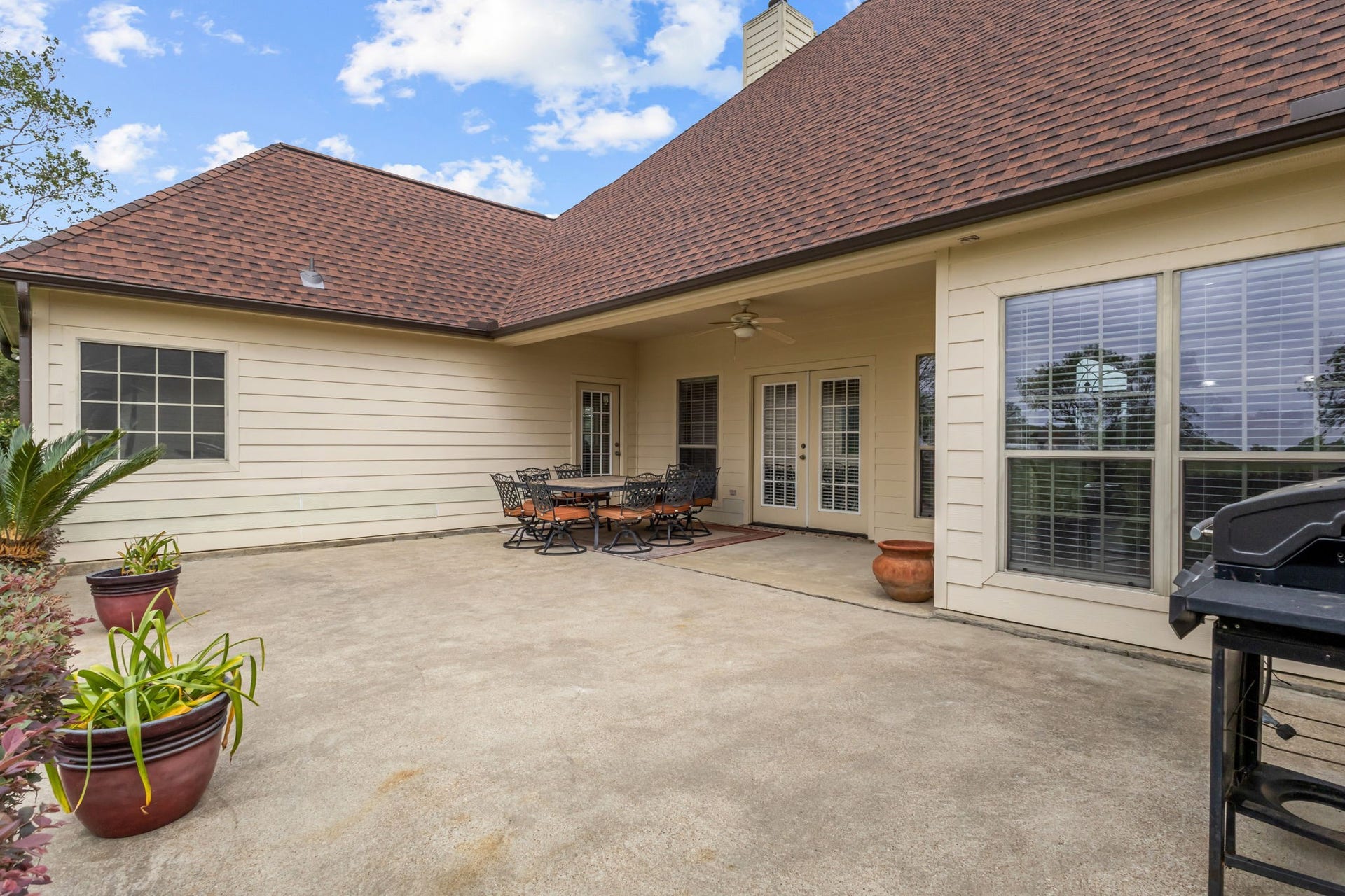 11010 Madison Court, Beaumont, TX 77705 Extended back patio featuring both covered and open areas, offering plenty of space for outdoor entertaining, dining, and relaxation. French doors provide convenient access to the home, creating a welcoming space to enjoy outdoor living.