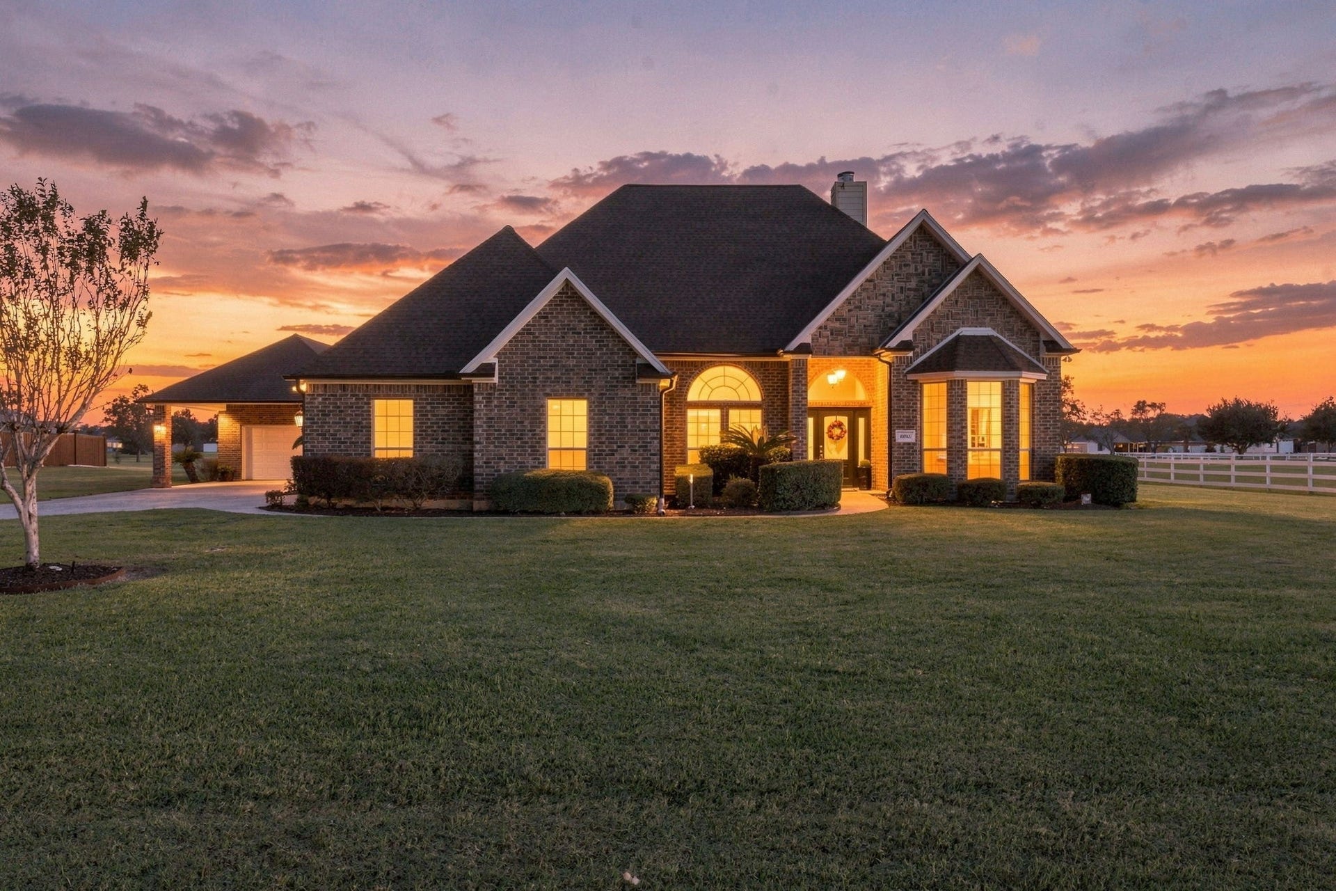 11010 Madison Court, Beaumont, TX 77705 Stunning twilight view showing this beautiful brick home's elegant details, inviting illuminated entryway, manicured landscaping and expansive front lawn.