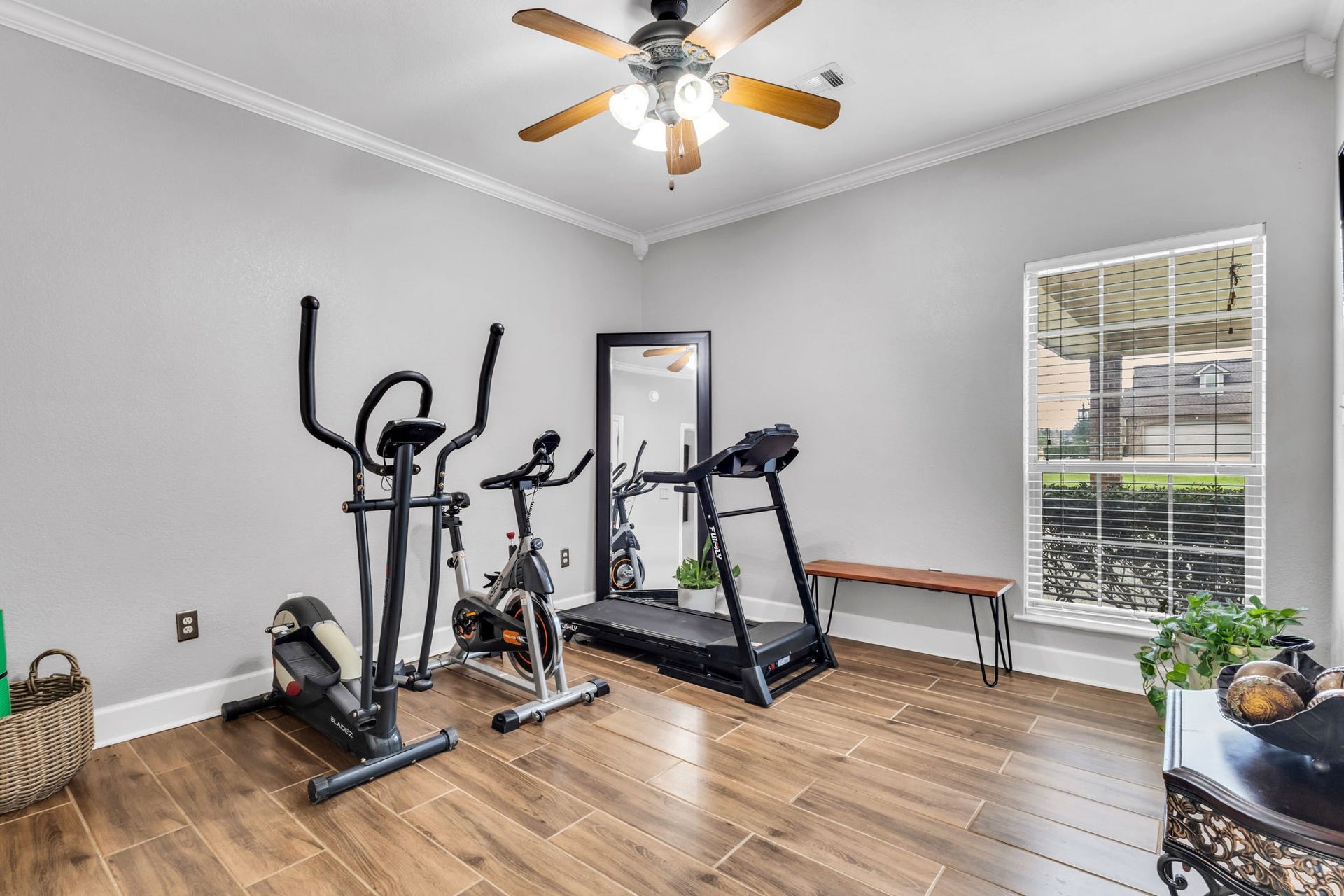 11010 Madison Court, Beaumont, TX 77705 Versatile second guest bedroom currently used as a home gym, featuring wood-look flooring, crown molding, ceiling fan, and natural light. This flexible space can easily accommodate a variety of needs.