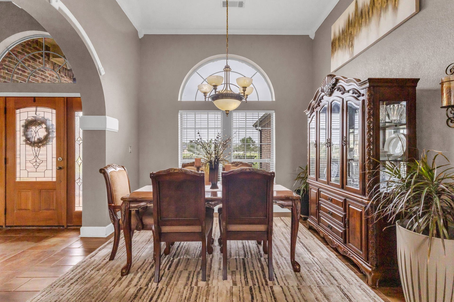 11010 Madison Court, Beaumont, TX 77705 Formal dining room featuring high ceilings, an elegant lighting, arched window, and decorative architectural details. Conveniently located just off the entryway, offering a welcoming space for gatherings and entertaining.