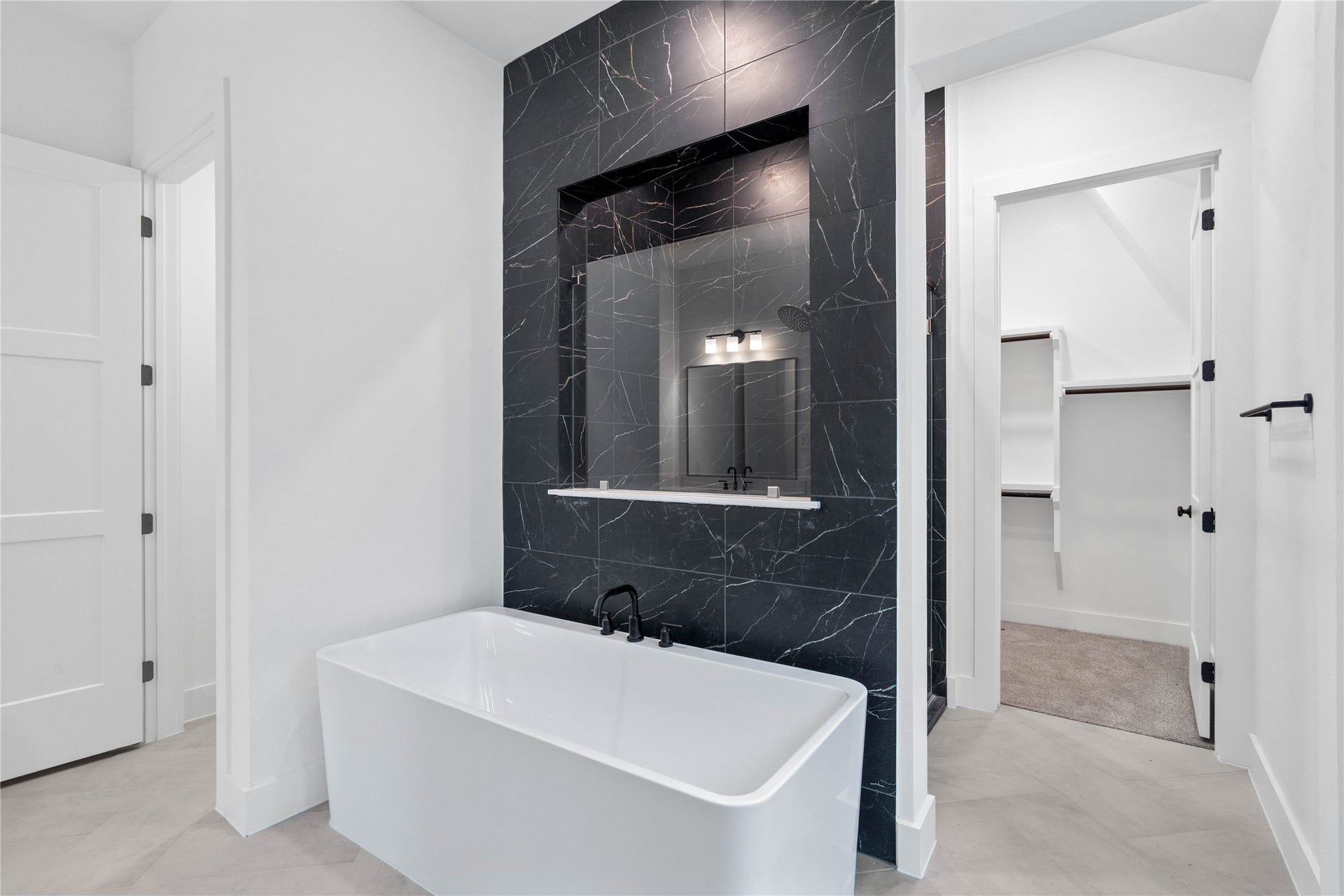 17728 Gold Saddle Lane, Magnolia, TX 77354 This alternate view of the primary bathroom showcases a large soaking tub perfect for unwinding after a long day, walk-in shower with a stylish tile surround, and a large walk-in closet!