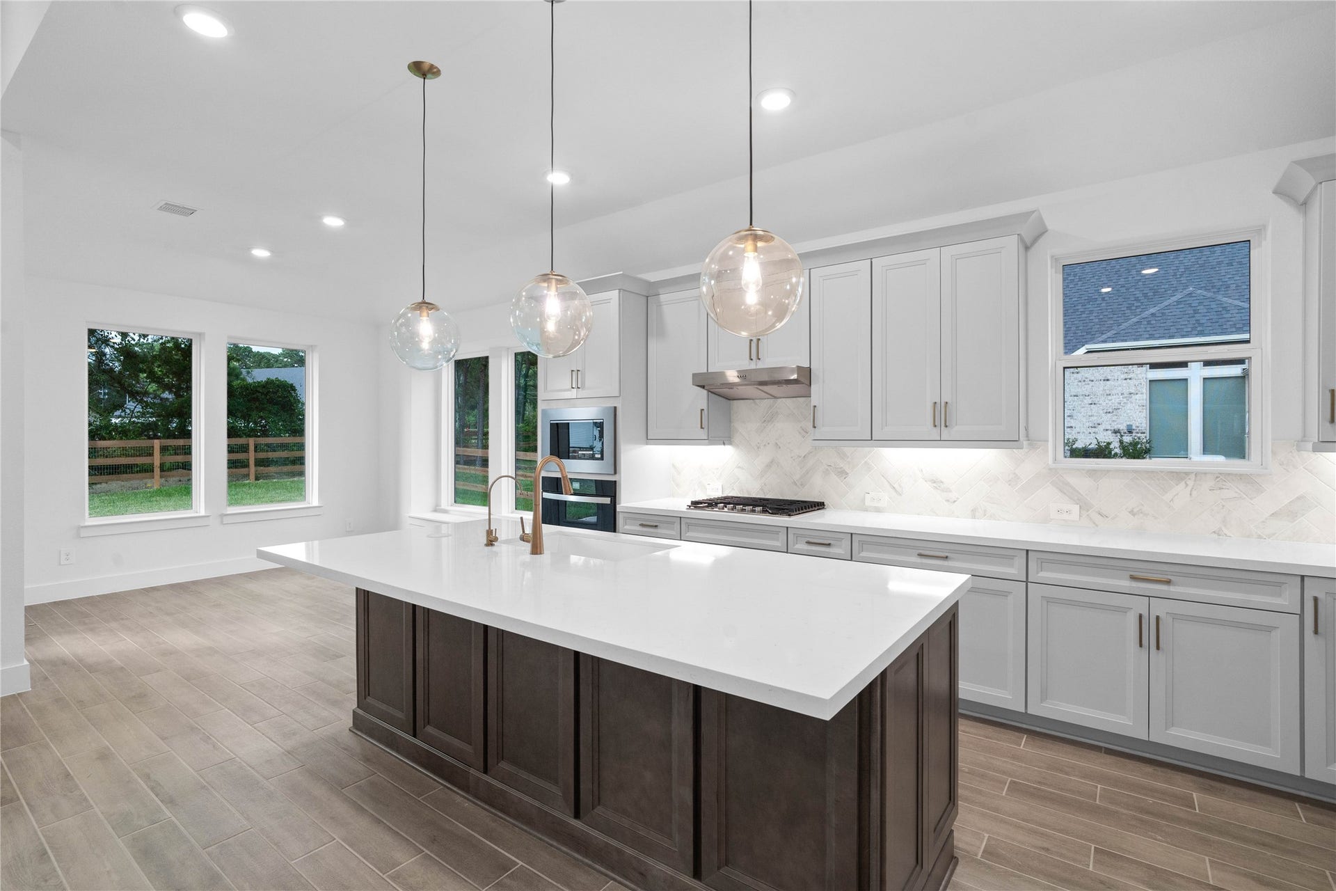 17728 Gold Saddle Lane, Magnolia, TX 77354 An expansive quartz island anchors the heart of the kitchen, showcasing a premium extended bar top that creates the ultimate hub for entertaining guests or enjoying casual conversation.