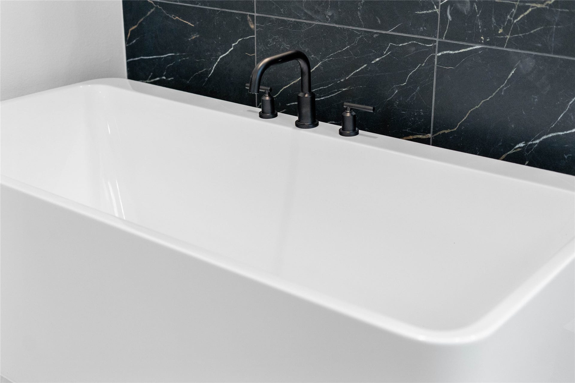 17728 Gold Saddle Lane, Magnolia, TX 77354 Indulge in the primary bath's deep, built-in soaking tub with elegant matte black fixtures and a sleek black tile surround for a true spa-like retreat.