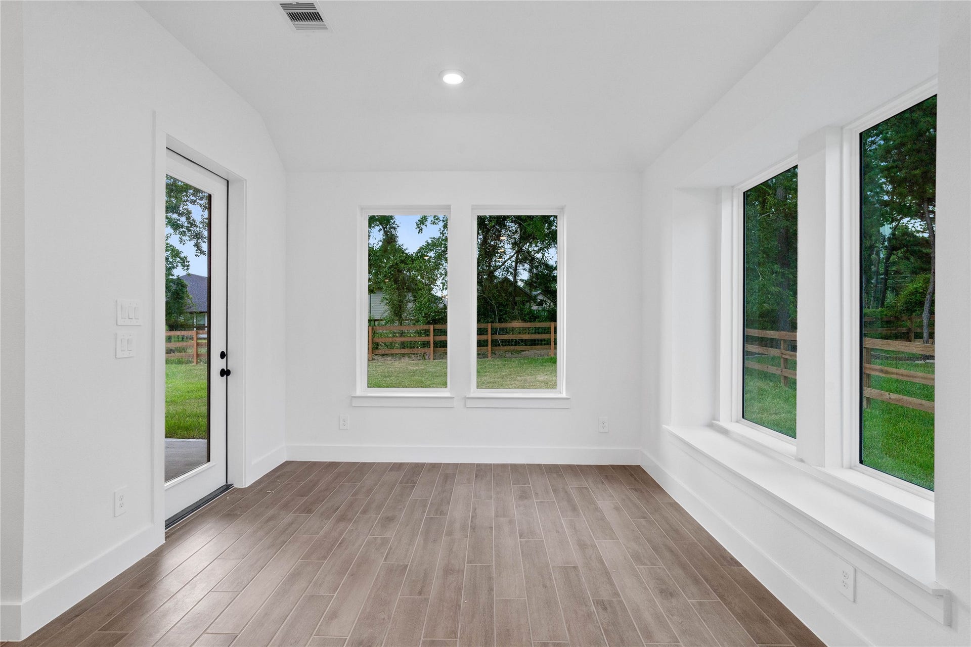 17728 Gold Saddle Lane, Magnolia, TX 77354 Create lasting memories around the table with family and friends in the dining! It showcases sloped ceilings, large windows, window seat, wood tile flooring, and recessed lighting for a warm and welcoming atmosphere. An access door to the back covered patio and backyard is strategically placed to create a seamless indoor-to-outdoor living space, making it perfect for entertaining.