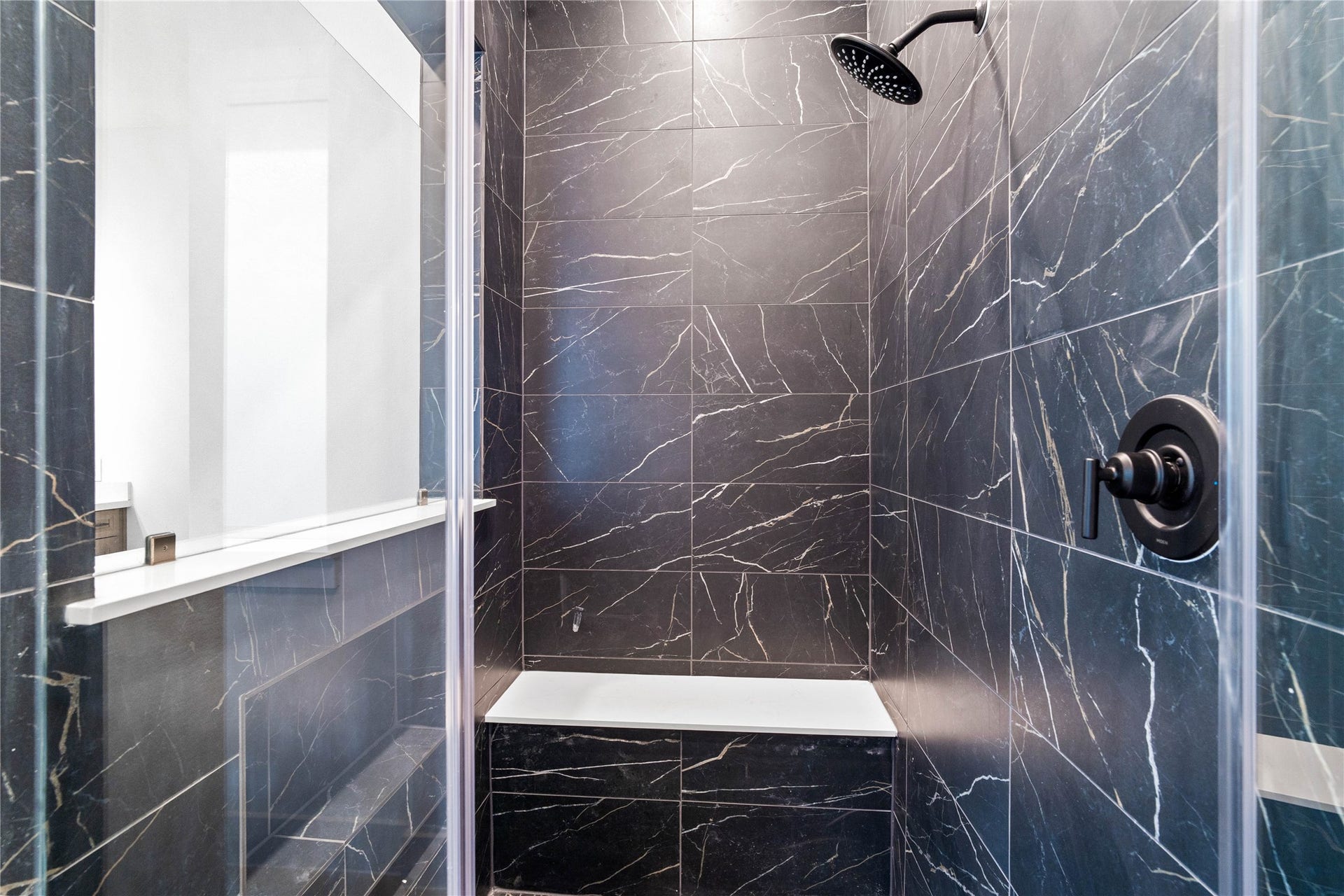 17728 Gold Saddle Lane, Magnolia, TX 77354 Enjoy a spa-like experience in this modern walk-in shower with built-in seat, niche for shower supplies, fixed shower head and elegant porcelain tile surround.