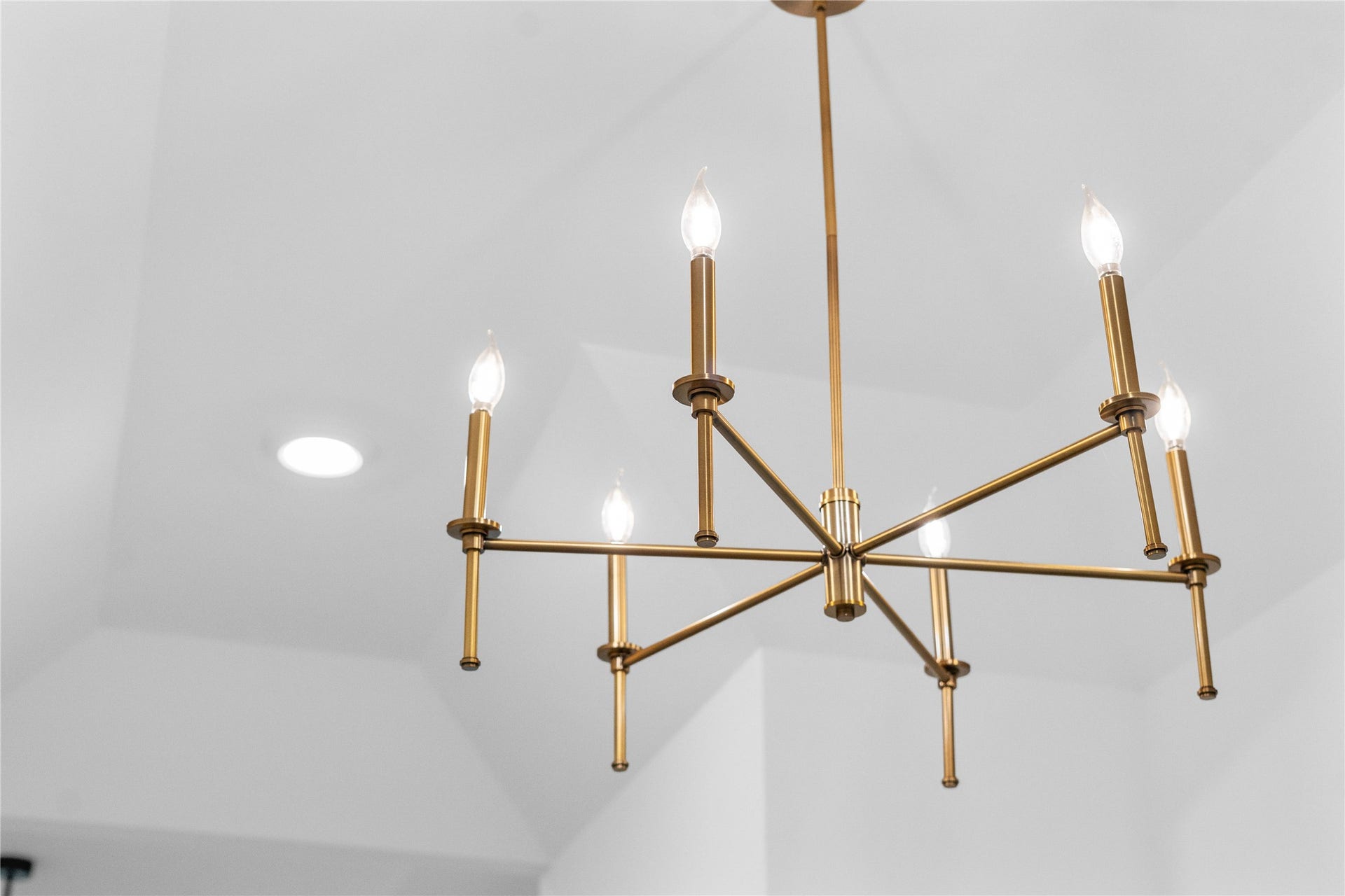 17728 Gold Saddle Lane, Magnolia, TX 77354 A striking modern brass chandelier acts as a sophisticated focal point in the entryway, casting a warm, elegant glow that immediately elevates the home's interior design.