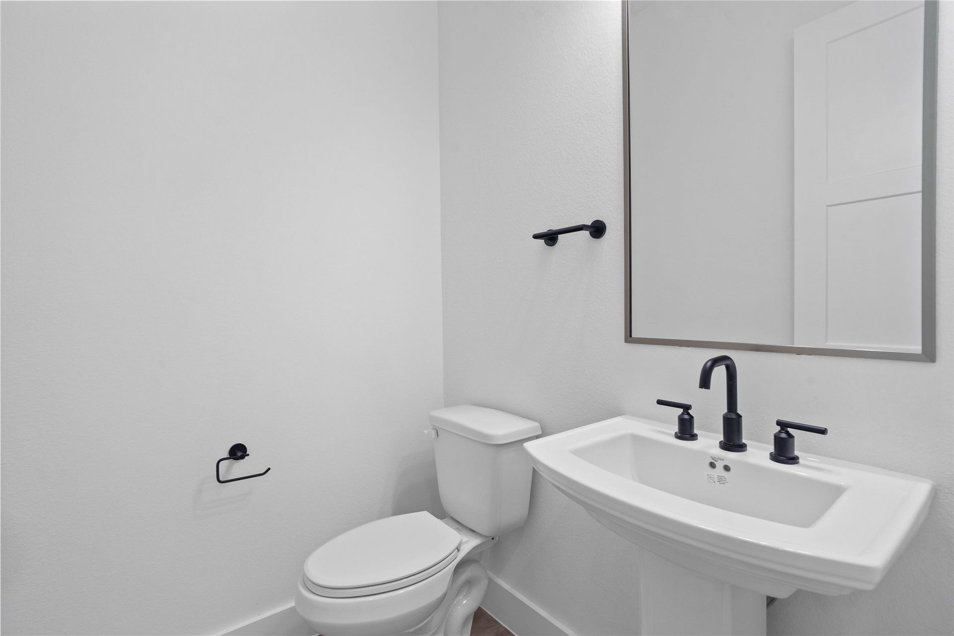 17728 Gold Saddle Lane, Magnolia, TX 77354 This crisp and contemporary powder room offers a sleek, minimalist design that provides a functional yet high-end experience for guests.